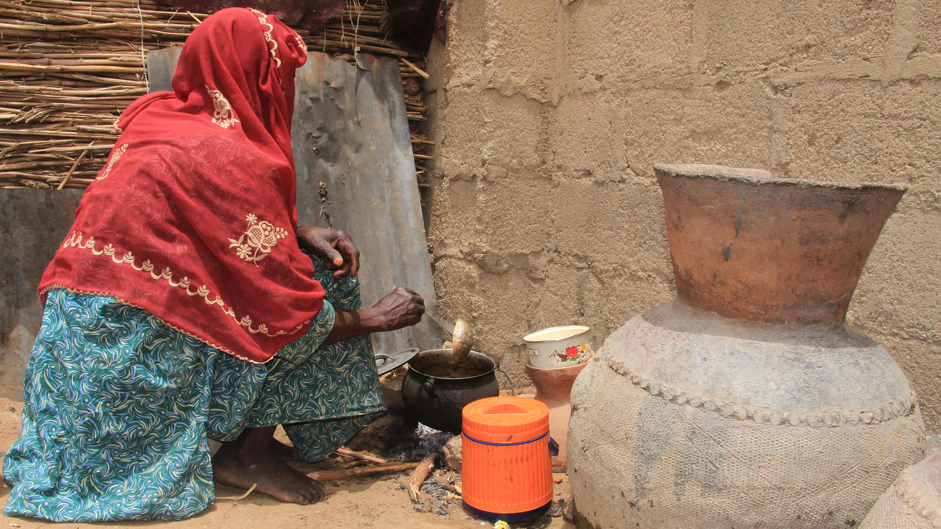 Eine Frau kocht an einer offenen Feuerstelle in Maiduguri (Nigeria)
