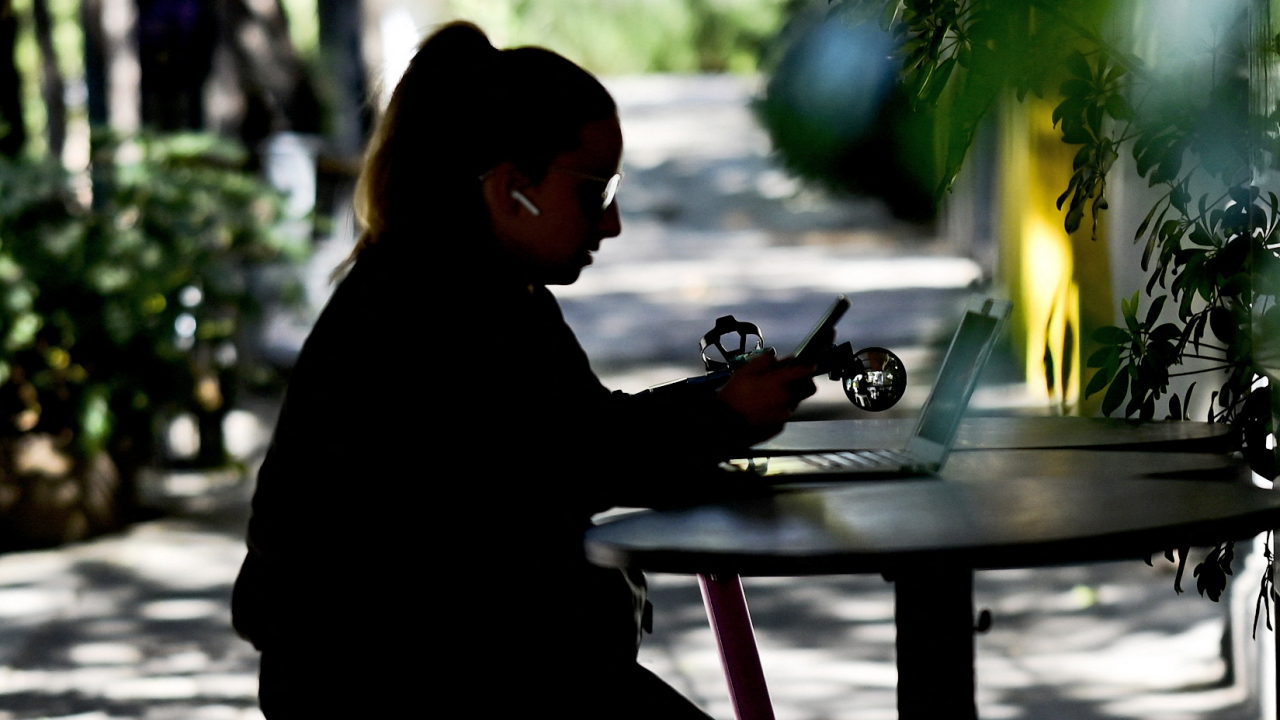 Frau mit Smartphone und Laptop | AFP