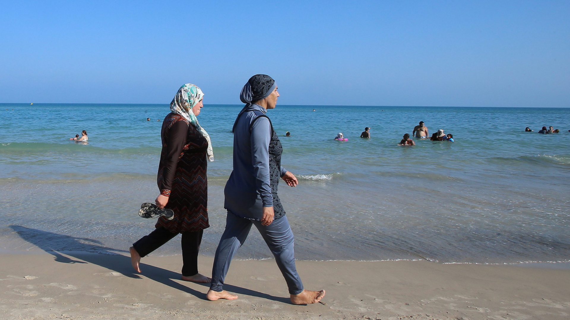 Frauen laufen am Strand von Bizerte in Tunesien. | dpa