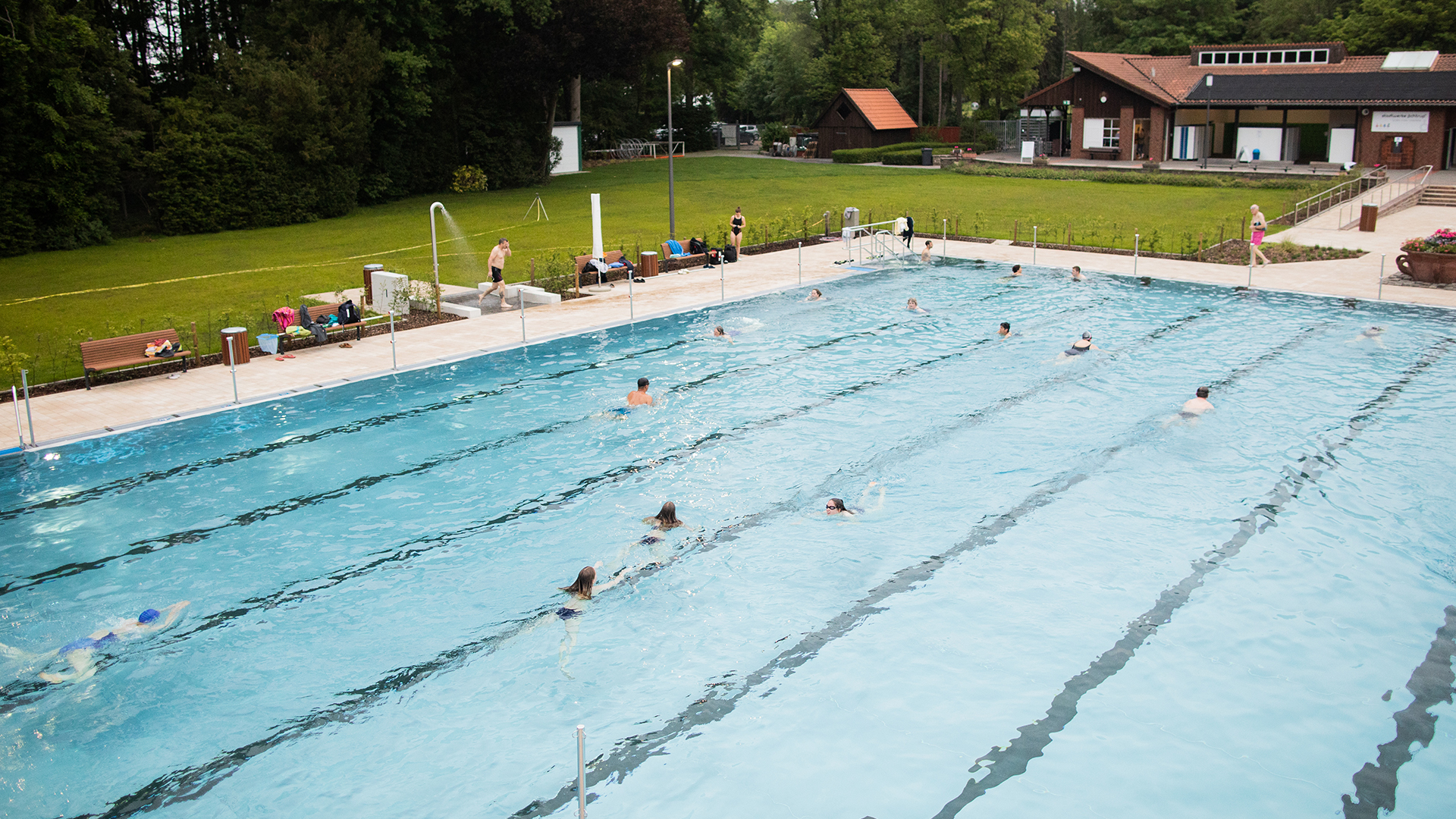 Die ersten Gäste ziehen ihre Bahnen im Schwimmbecken im Bergfreibad in Ochtrup (Nordrhein-Westfalen). | dpa