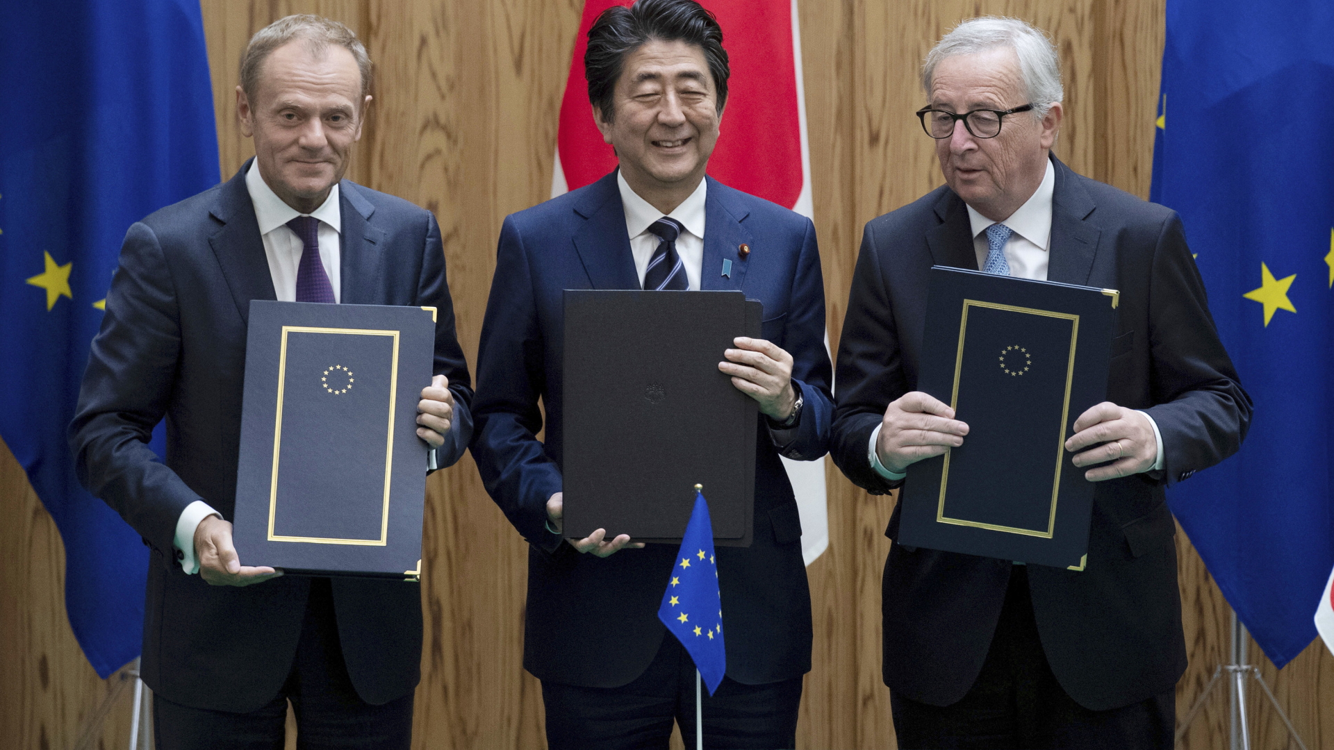 Donald Tuck, Shinzo Abe und Jean-Claude Junker mit dem Vertrag | AP