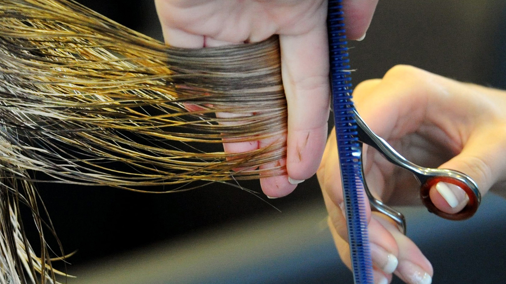 Eine Friseurin schneidet einer Kundin die Haare.