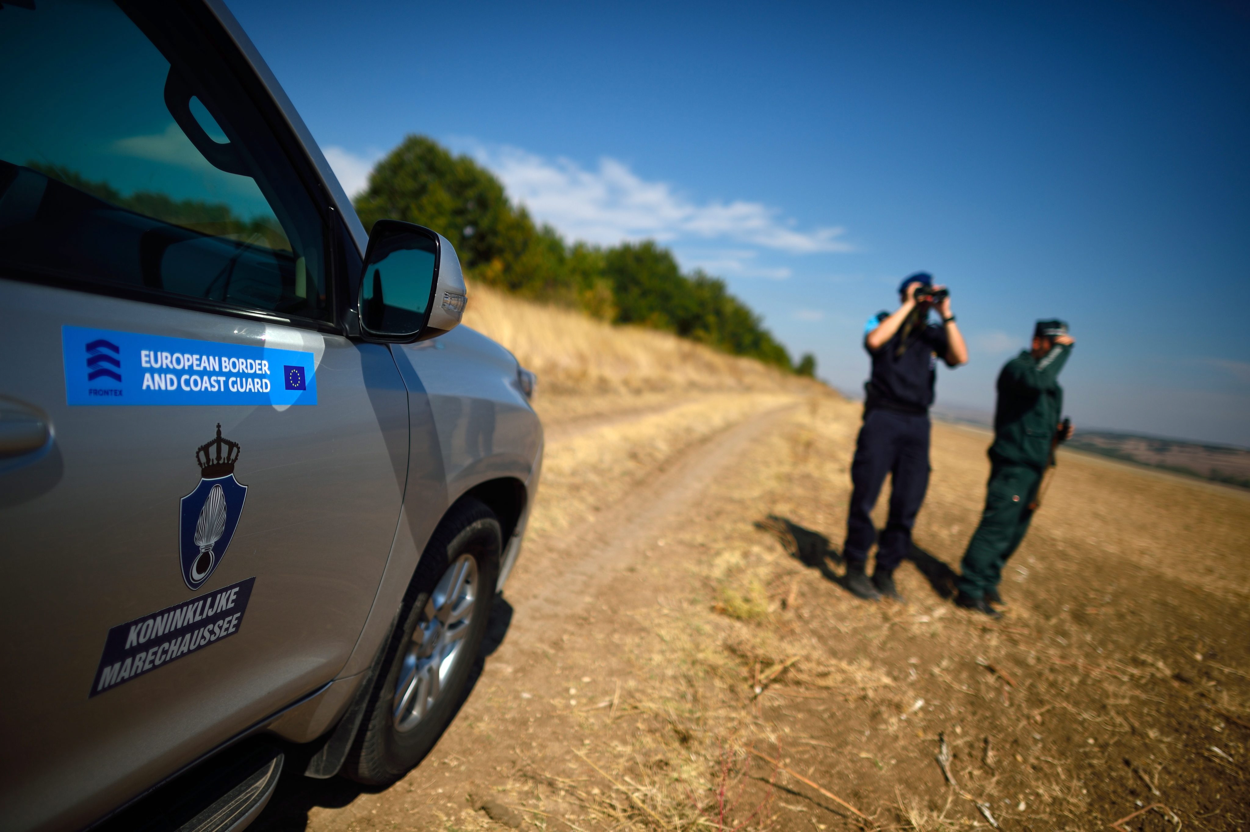 Frontex-Mitarbeiter stehen neben einem Auto der Agentur | picture alliance / dpa