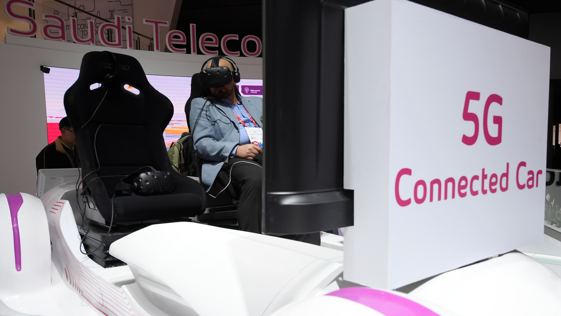 Saudi-Telecom-Stand auf dem MWC in Barcelona. Hier versucht ein Mann die Kombination aus VR-Brille und Autofahren.  | AFP