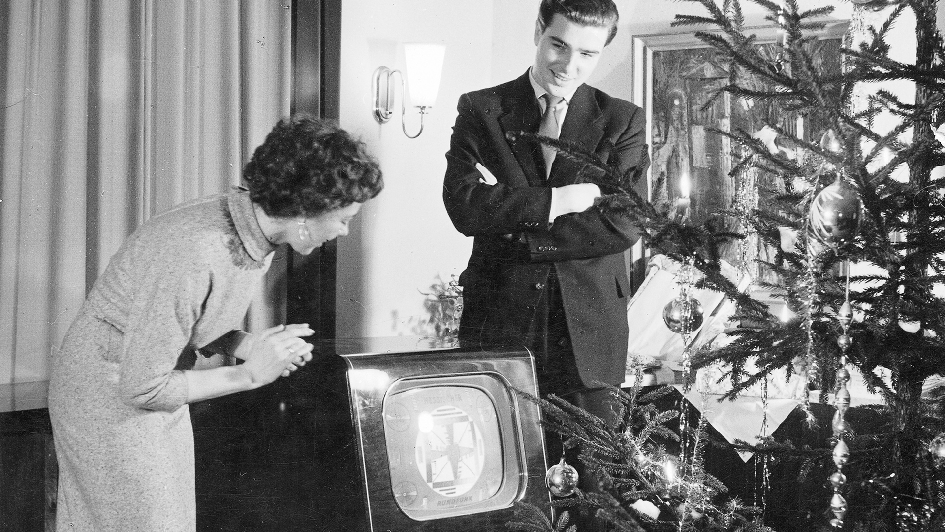 Ein junges Paar betrachtet den neuen Fernseher an Heiligabend (Aufnahme aus den 1950er Jahren) | Bildquelle: picture-alliance / Helga Lade Fo