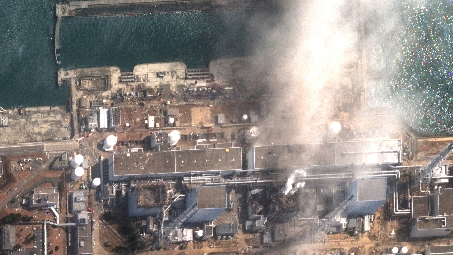 Satellitenaufnahme der Reaktorgebäude von Fukushima, über die nach mehreren Explosionen im März 2011 Rauch aufsteigt | dpa