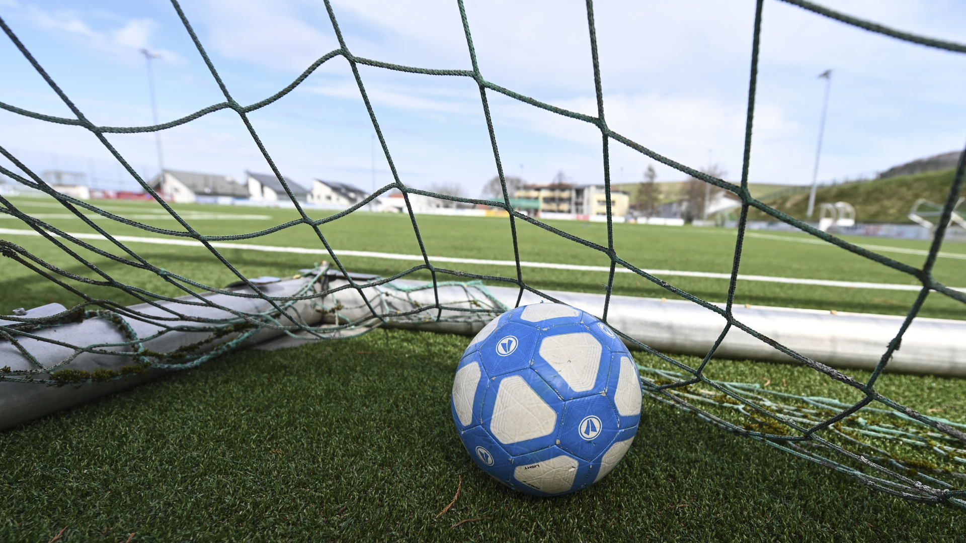 Ein Fußball liegt in einem Tor auf dem leeren Fußballplatz. | dpa