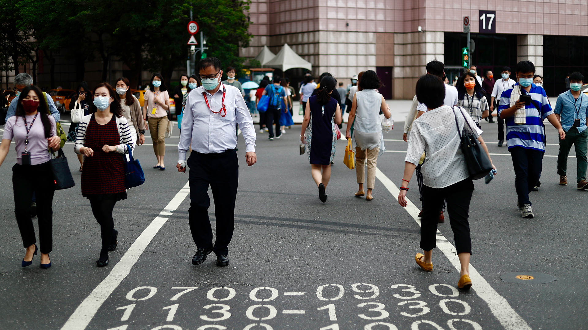 Fußgänger mit Mundschutz überqueren eine Straße in Taipeh (Taiwan). | EPA
