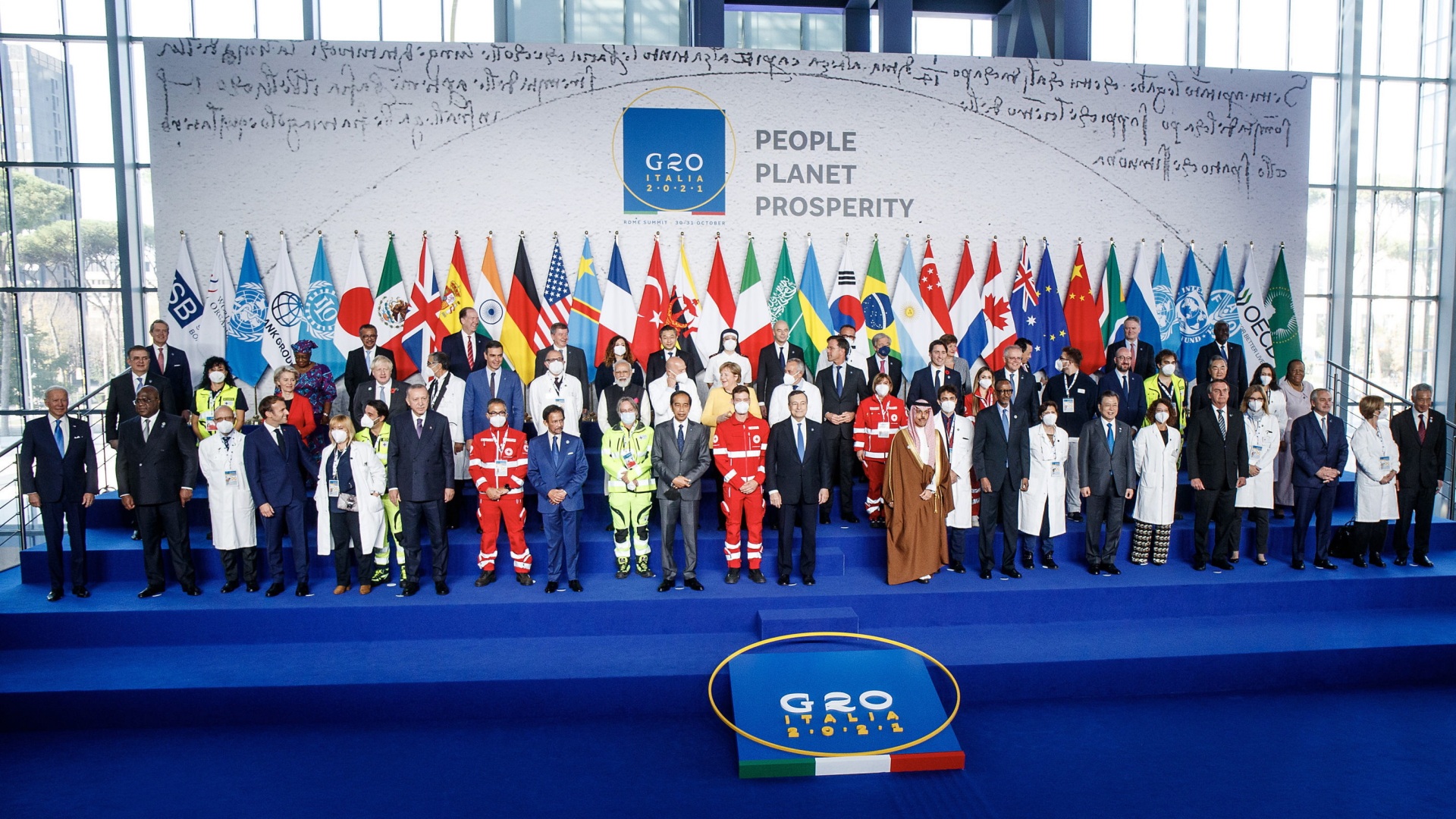 Die G20-Staats- und Regierungschefs zusammen mit Corona-Helfern beim Gipfel-Familienfoto. | EPA