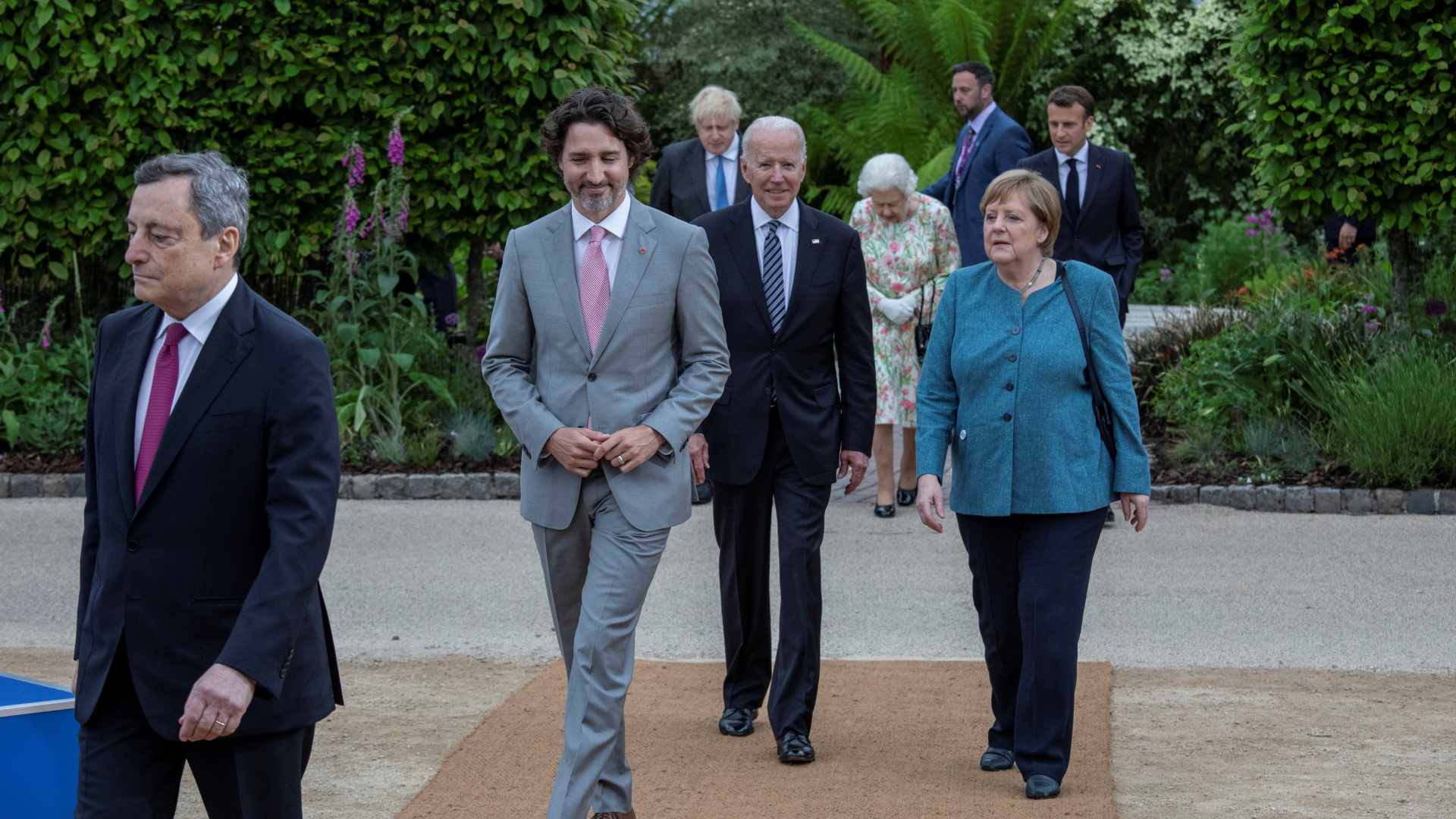 Mario Draghi, Justin Trudeau, Joe Biden, Angela Merkel, Boris Johnson, Emmanuel Macron und Königin Elizabeth II. gehen durch einen Garten. | REUTERS