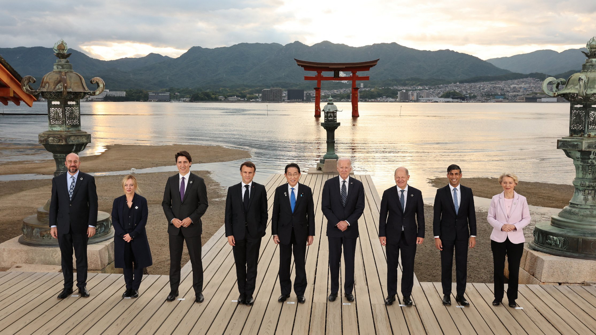 Gruppenbild der G7-Staats- und Regierungschefs am Itsukushima-Schrein auf der Insel Miyajima nahe Hiroshima, im Hintergrund die untergehende Sonne.