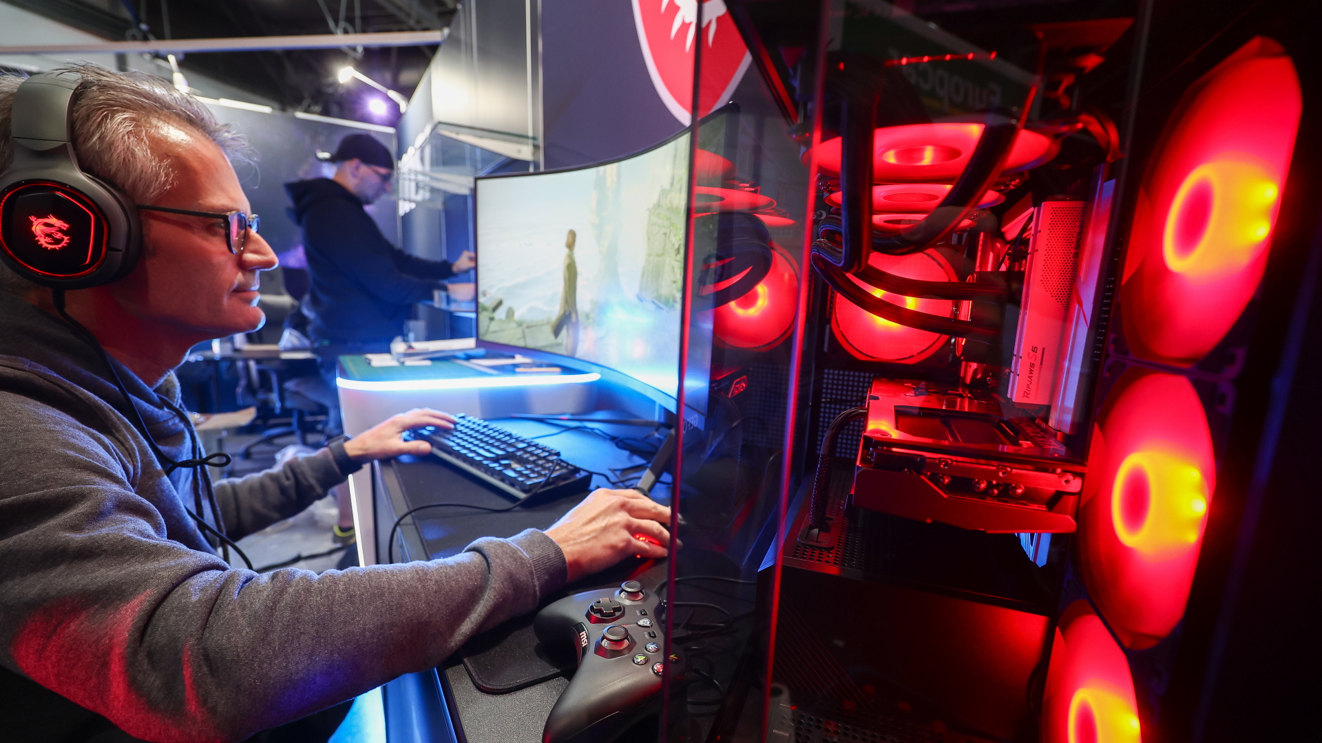 Ein Mann richtet einen Gamescomputer für einen Messestand ein