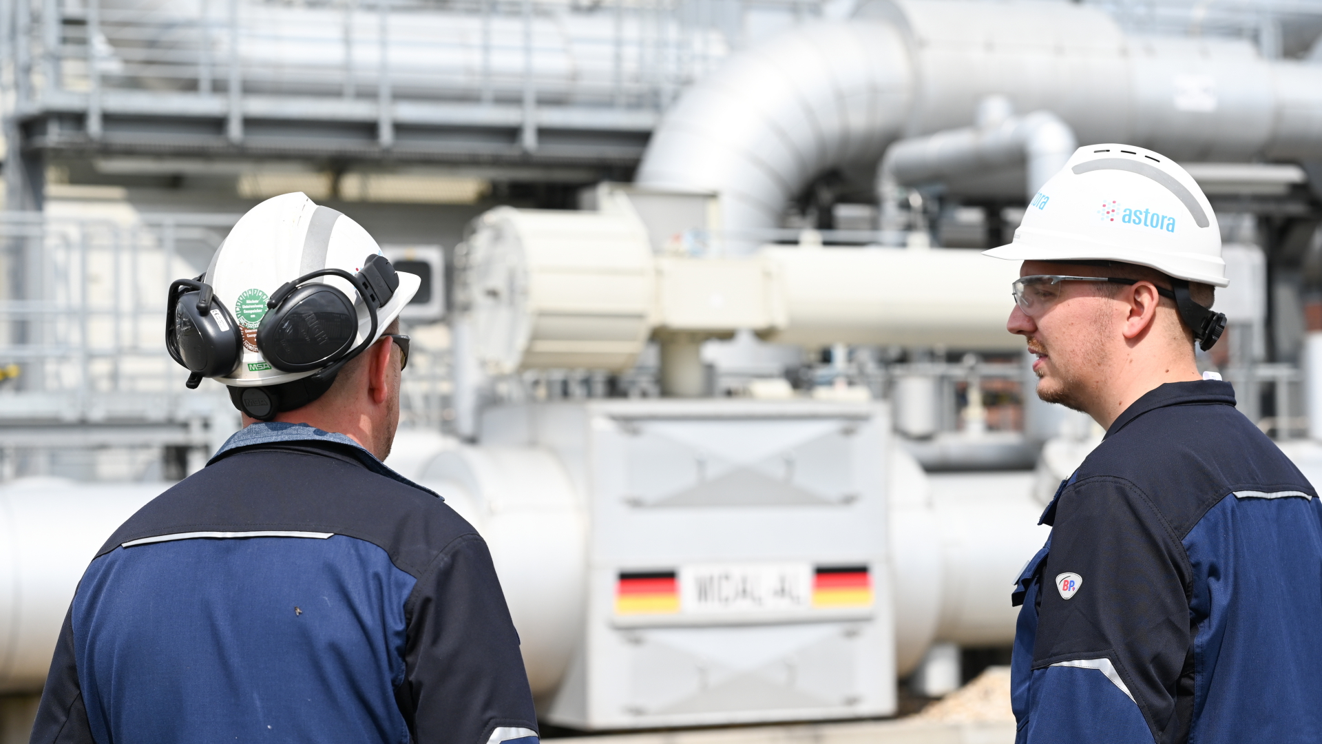 Zwei Mitarbeiter stehen auf dem Gelände des Gasspeichers Jemgum in Niedersachsen.