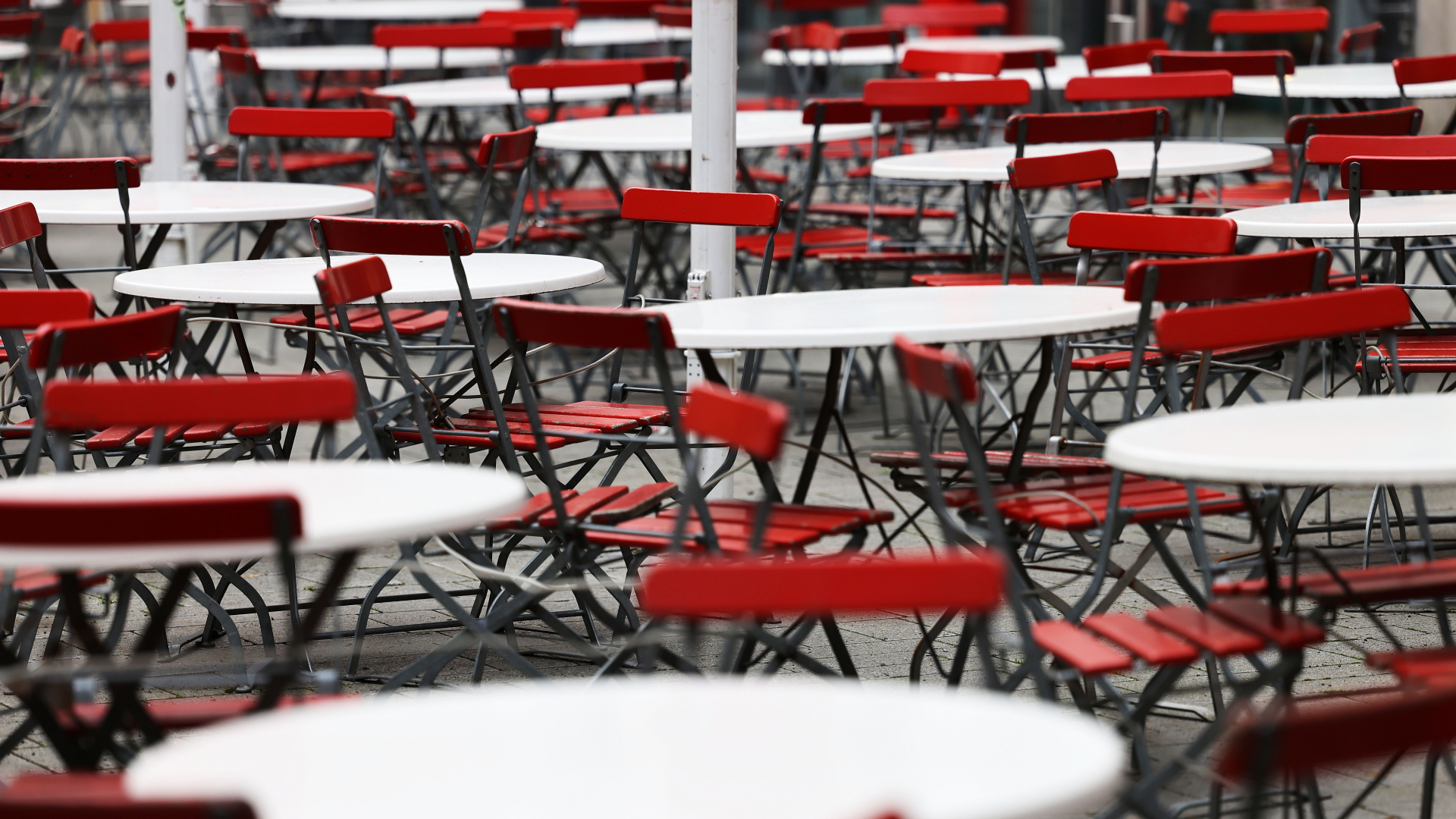 Leere Tische und Stühle stehen vor einem Lokal in Köln | dpa