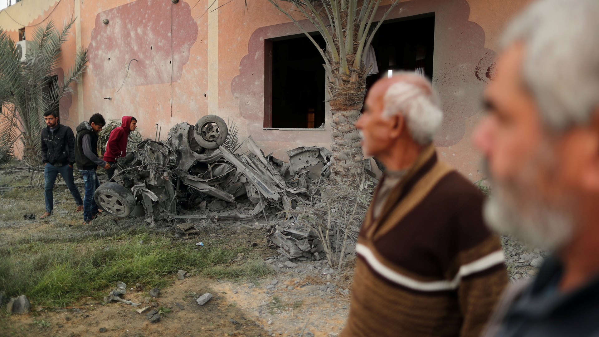 Männer schauen auf zerstörte Gegenstände im Gazastreifen. | Bildquelle: REUTERS