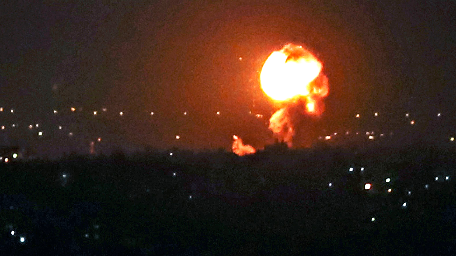 Ein Feuerball ist über einer nächtlichen Stadt zu sehen. | AFP