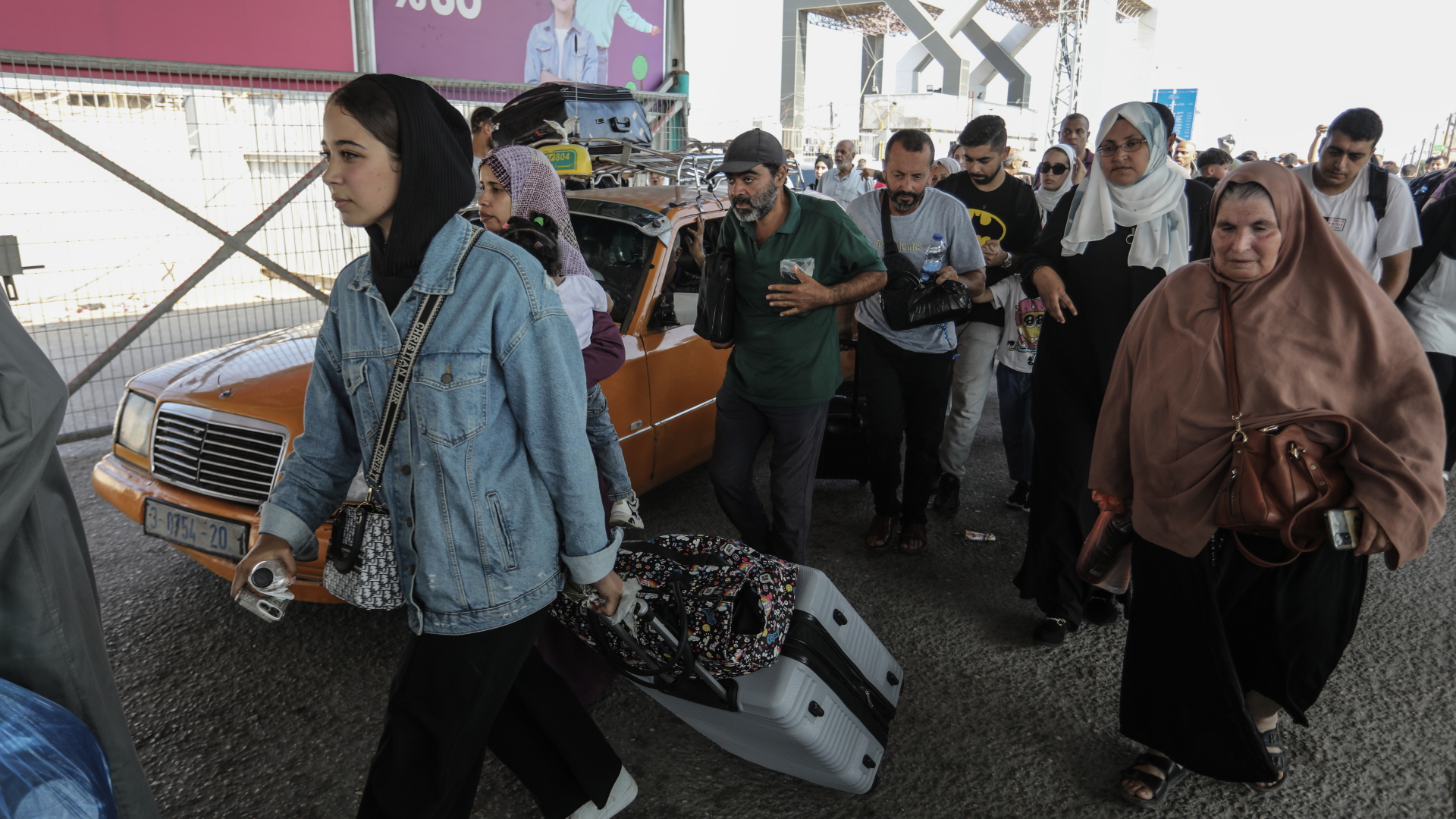 Menschen tragen Gepäck am Grenzübergang zwischen dem Gazastreifen und Ägypten.