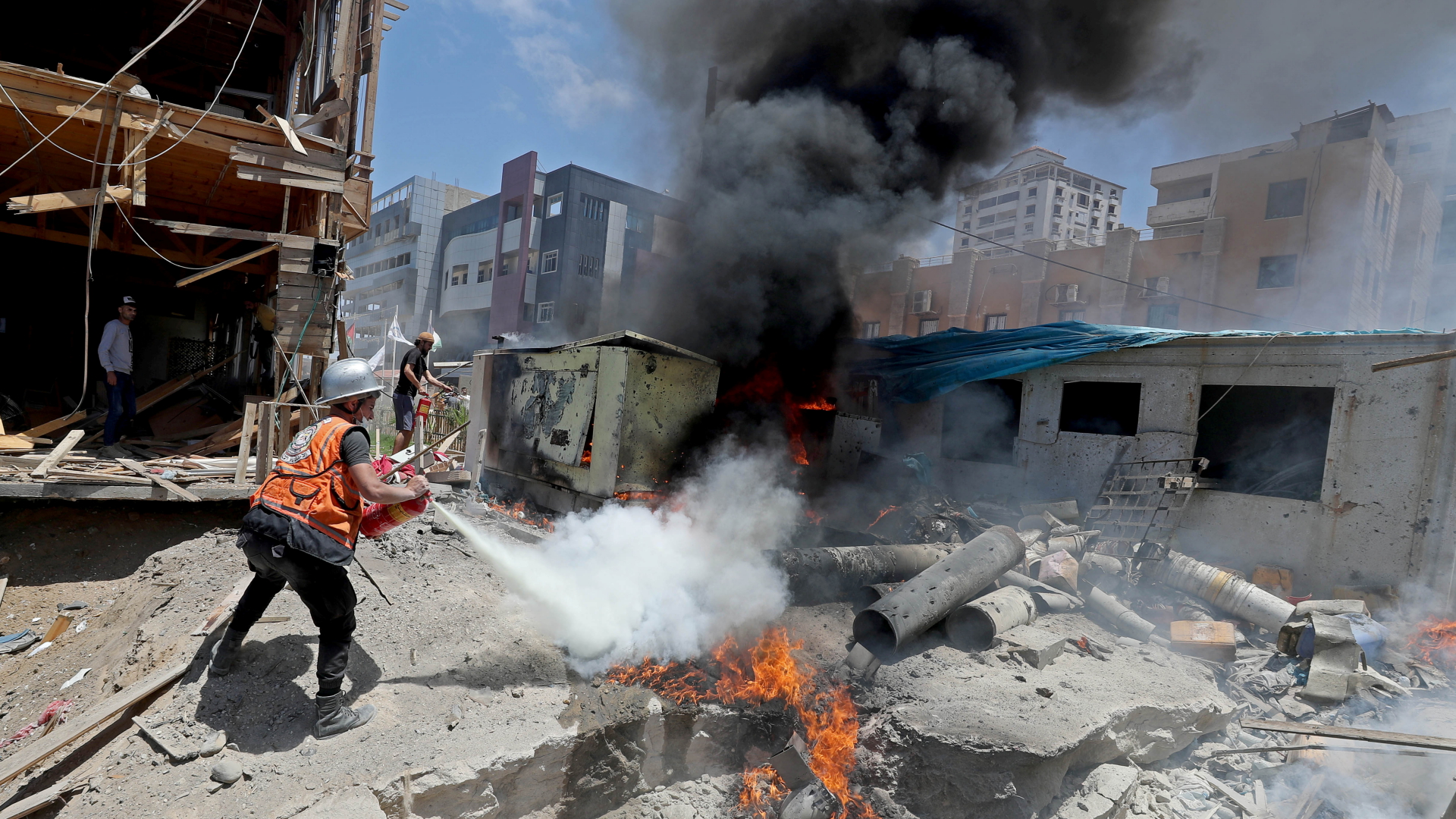 Ein Feuerwehrmann löscht brennende Trümmer in Gaza | REUTERS