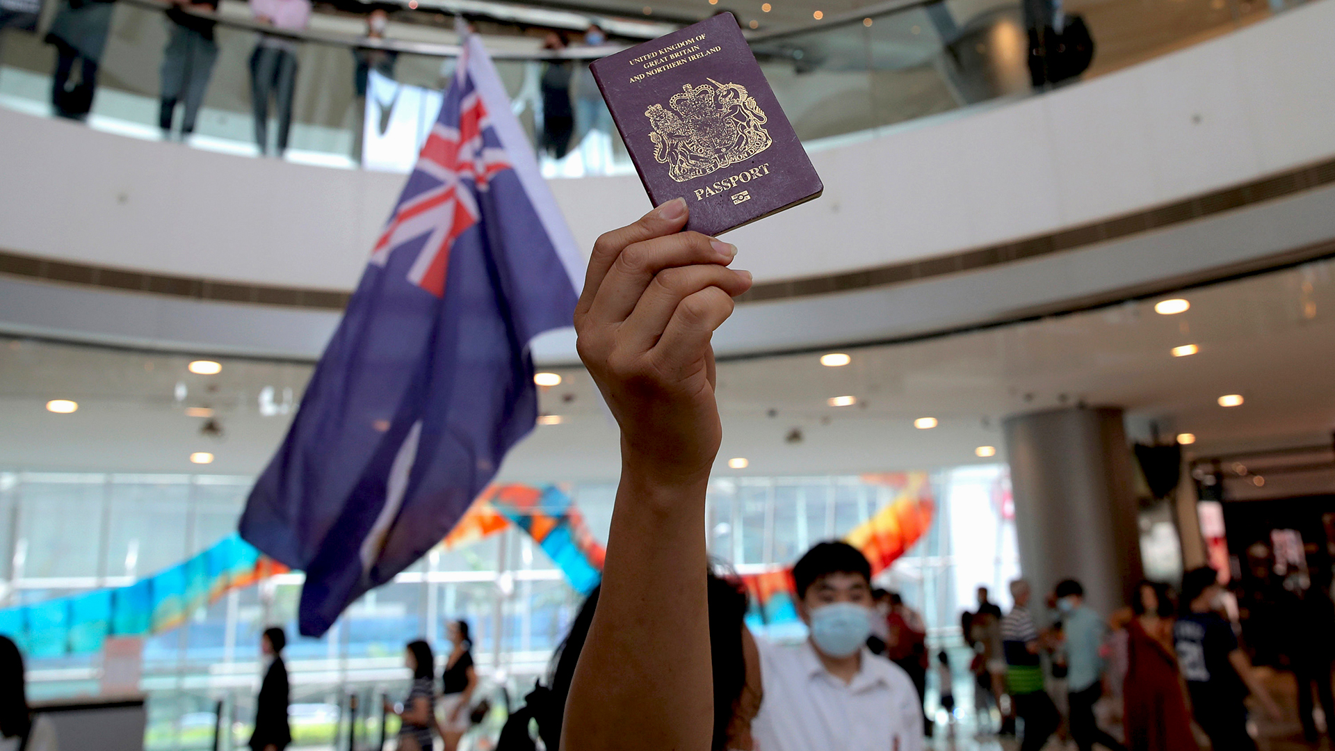 Ein Demonstrant hält einen Pass und eine Flagge hoch. | AP