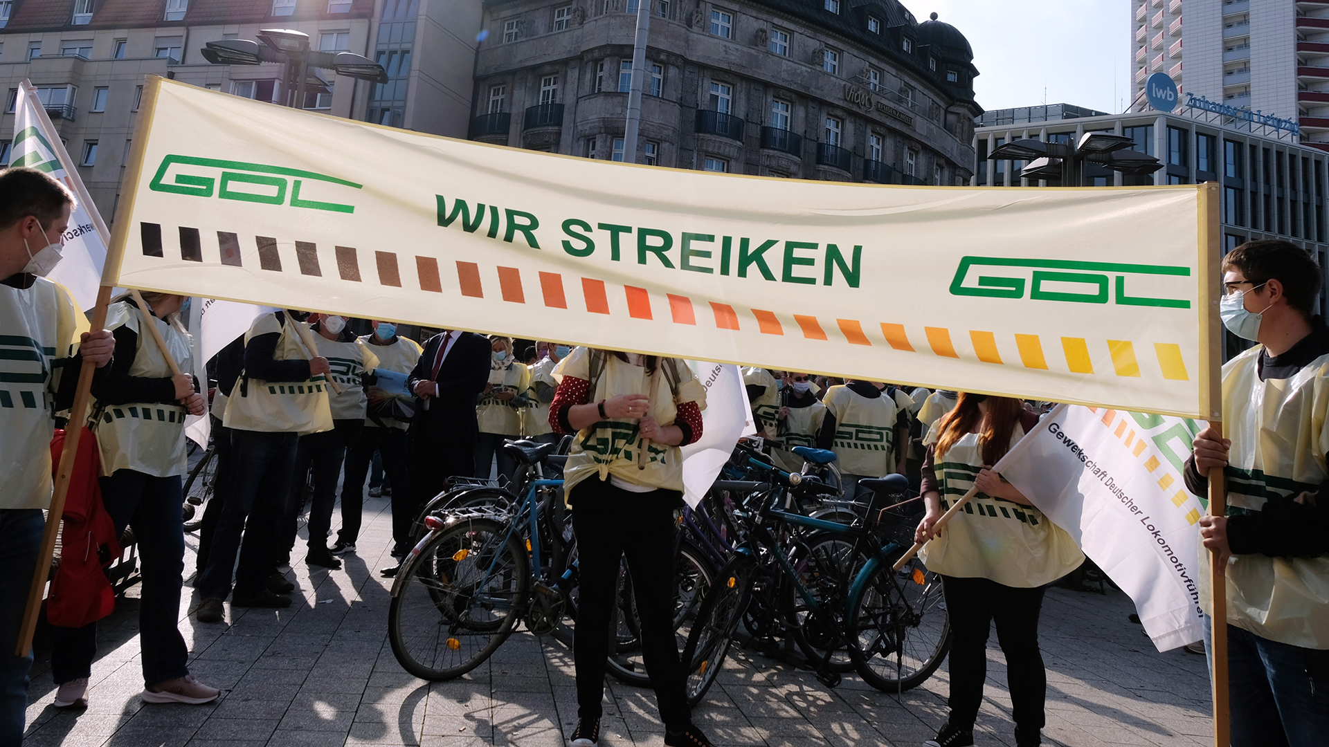 Teilnehmer einer Kundgebung der Gewerkschaft der Lokführer (GDL) stehen mit einem Transparent vor dem Hauptbahnhof in Leipzig.  | dpa