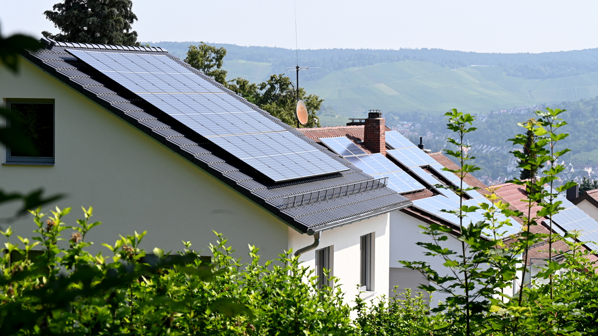 Dächer mit Solaranlagen auf Häusern an einem Hang
