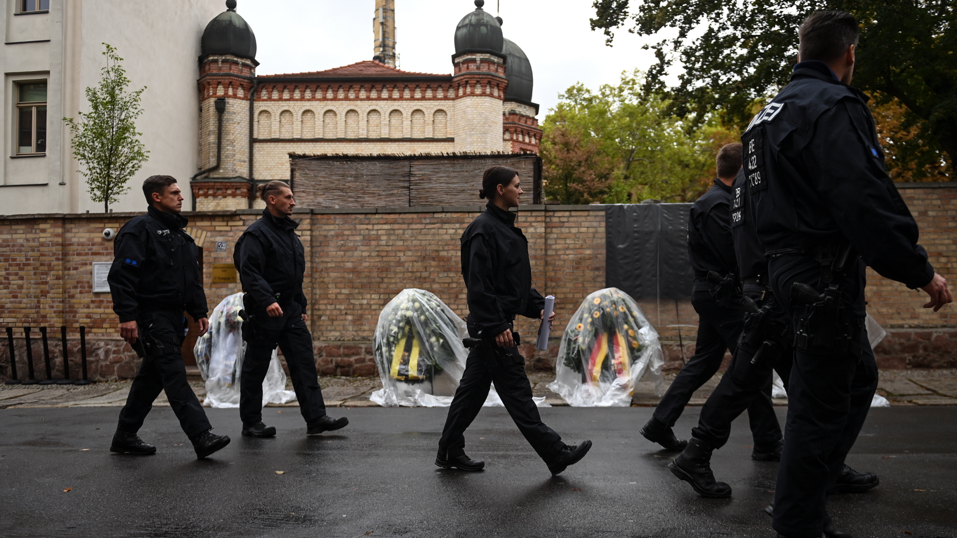 Polizisten vor Blumenkränzen an der Synagoge in Halle | dpa