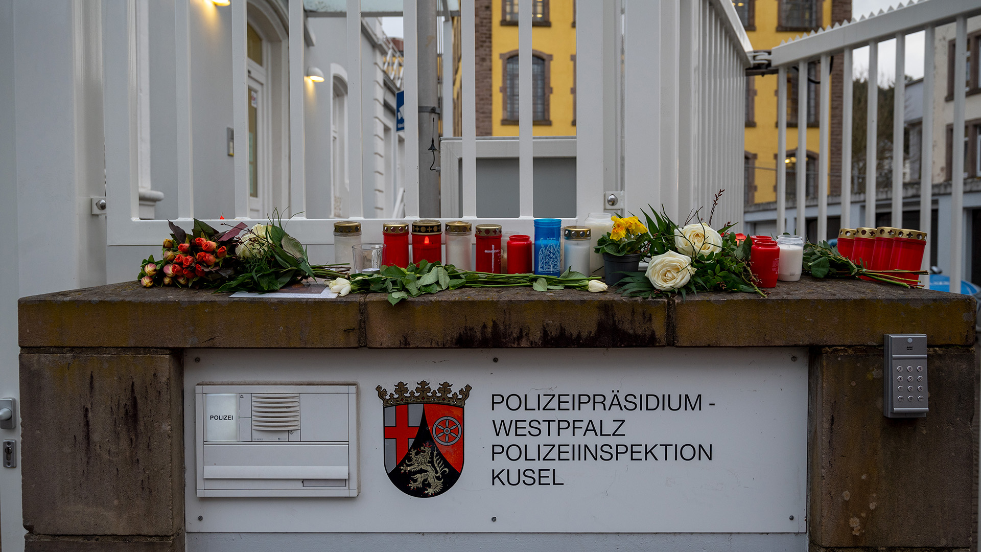 Blumen liegen und Kerzen stehen am Eingang der Polizei in Kusel. | dpa