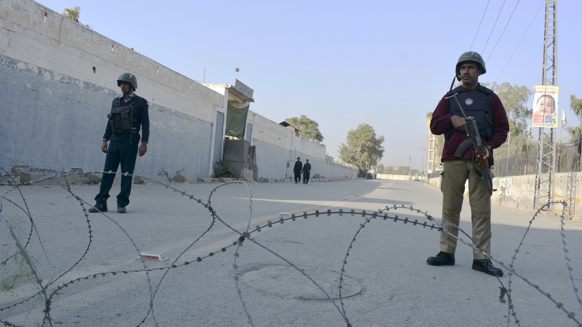  Sicherheitspersonal bewacht eine mit Stacheldraht blockierte Straße, die zu einem Gefängnis führt | dpa