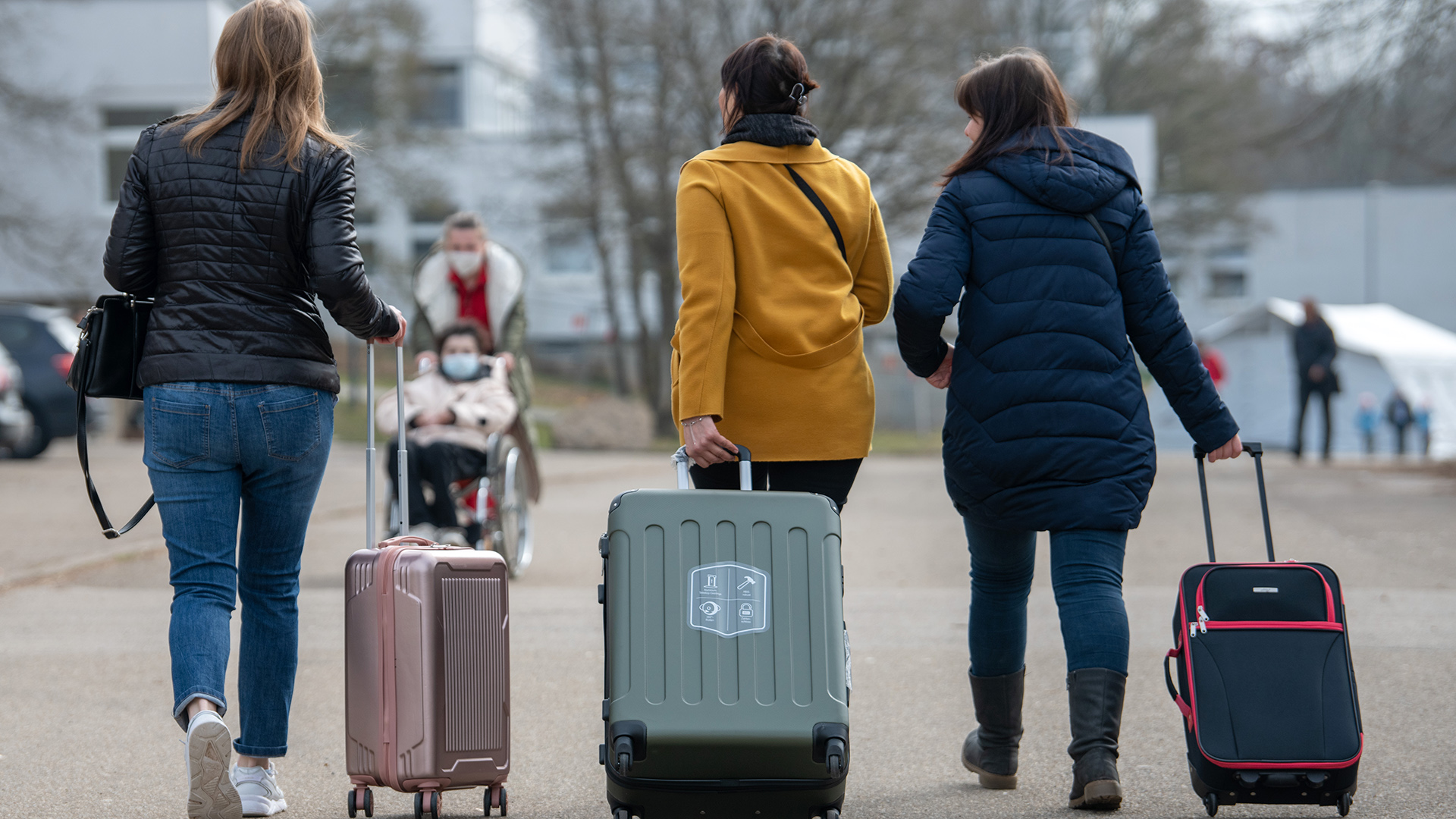 Drei aus der Ukraine stammende Frauen gehen in der Landeserstaufnahmestelle für Flüchtlinge (LEA) zu ihrem Quartier.  | dpa