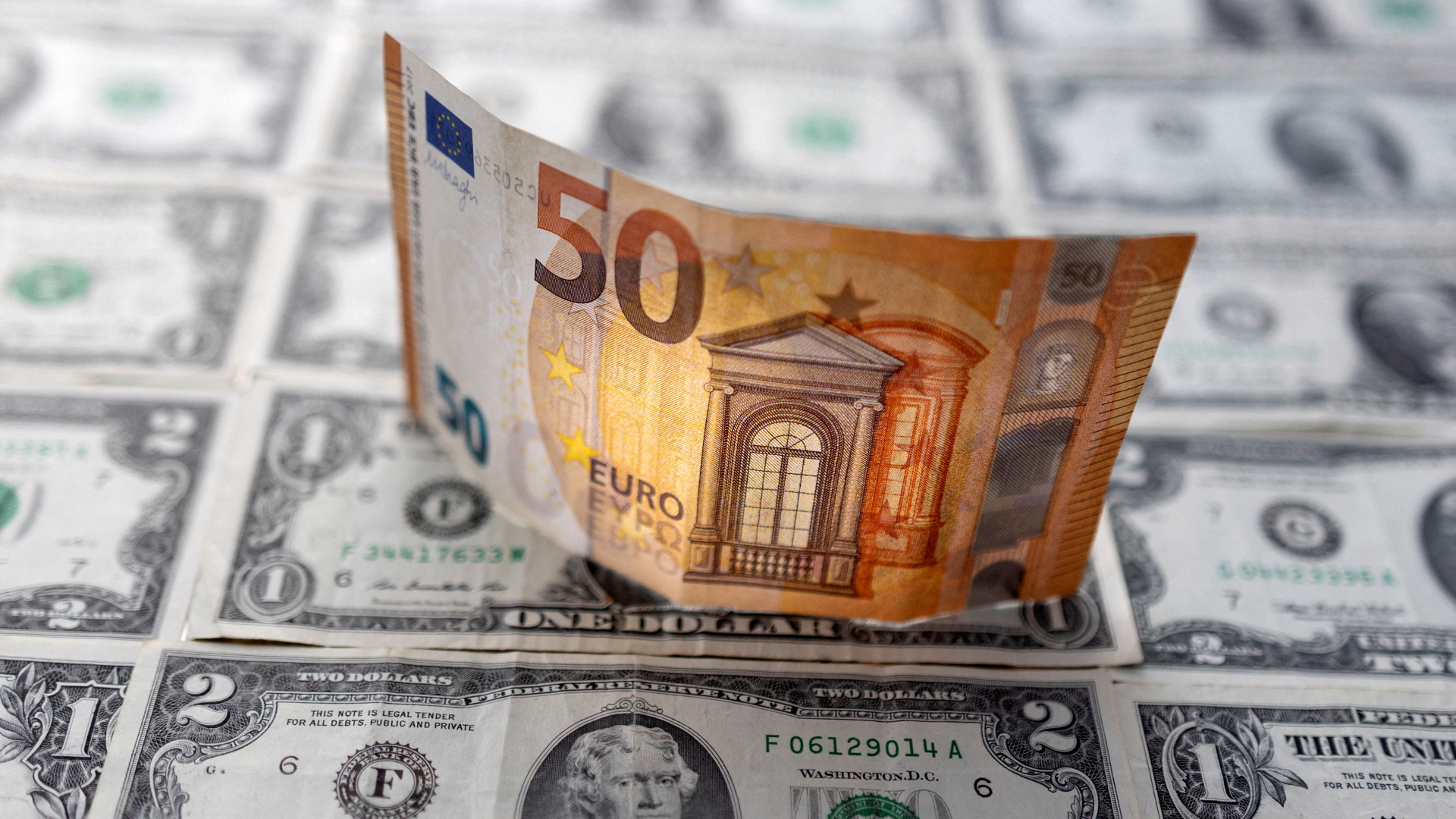 Eine 50-Euro-Banknote auf mehreren Dollar-Scheinen | REUTERS