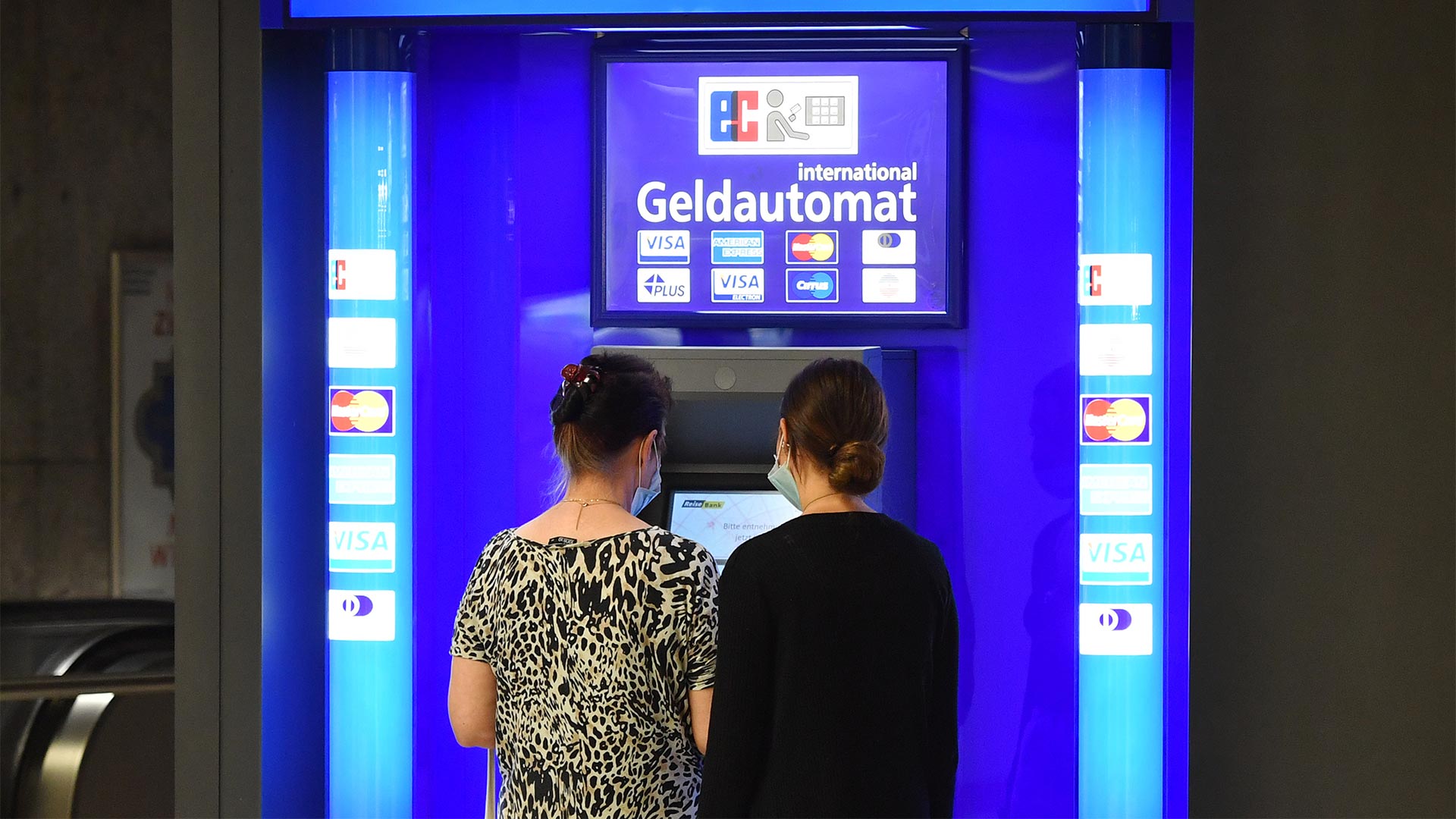 Kunden stehen vor einem Geldautomaten