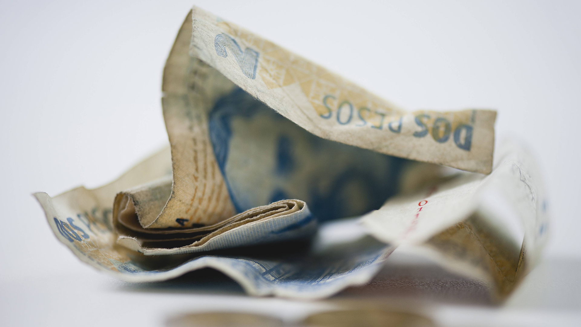 Zerknüllte argentinische Pesos-Geldscheine | imago images / PhotoAlto