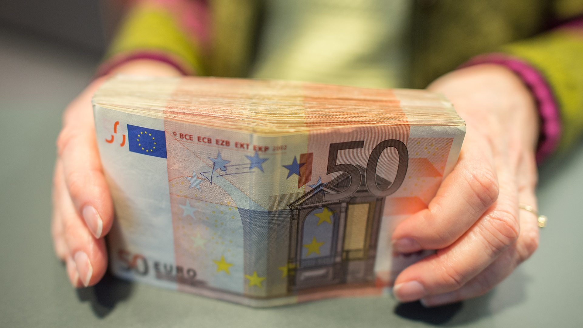 Eine Frau hält 50-Euro-Scheine in den Händen.  | picture alliance / dpa