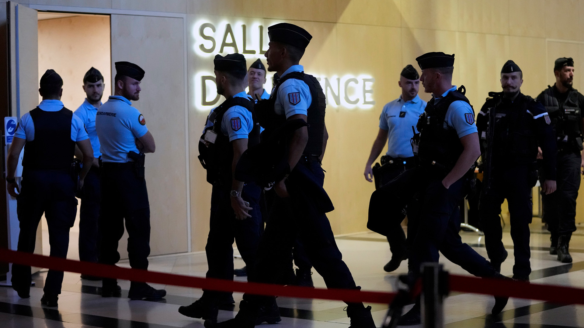 Gendarmen und Polizeibeamte gehen am Eingang des Sondergerichtssaals für den Prozess um die Anschläge von Nizza vorbei (Archivbild 21.09.22) | AP