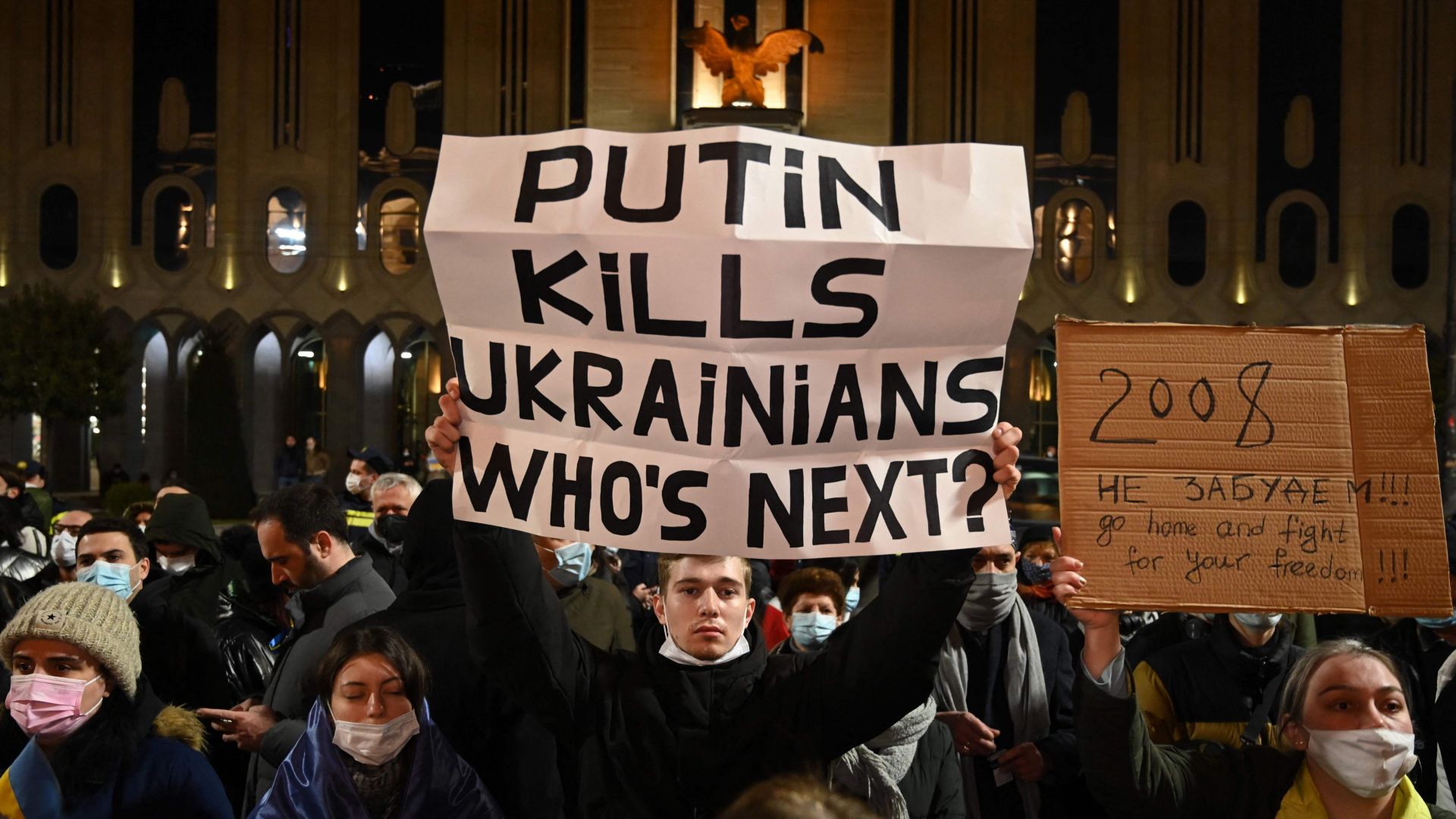 Ein Demonstrant in Georgien hält ein Plakat mit der Aufschrift: "Putin tötet Ukrainer. Wer ist als nächstes dran?" | AFP