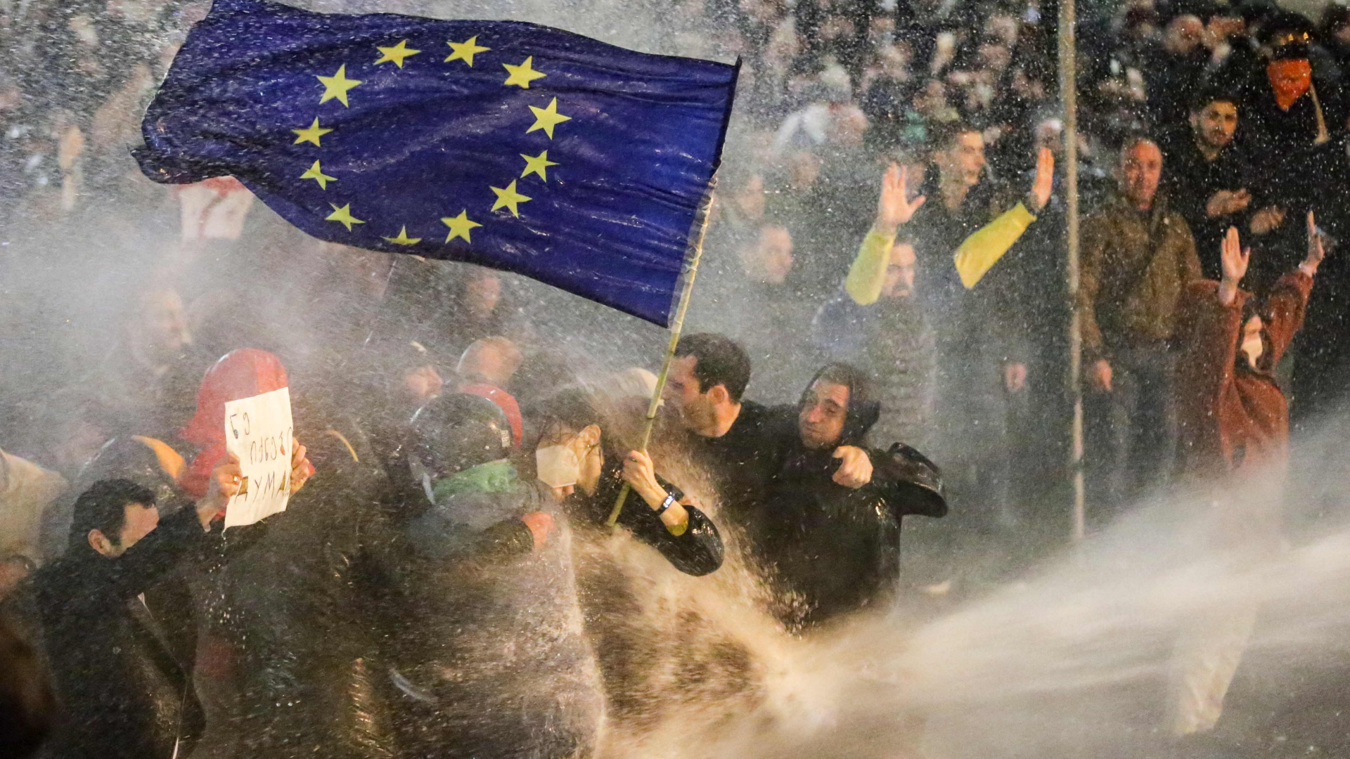 Demonstranten mit einer Europa-Flagge inmitten eines Wasserwerfer-Strahls der Polizei | AFP