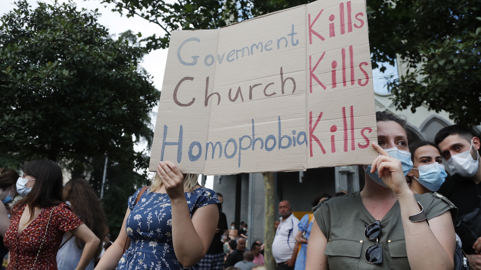 Bei einer Kundgebung gegen Gewalt in Tiflis halten zwei Frauen ein Schild: "Die Regierung tötet. Die Kirche tötet. Homophobie tötet." | EPA