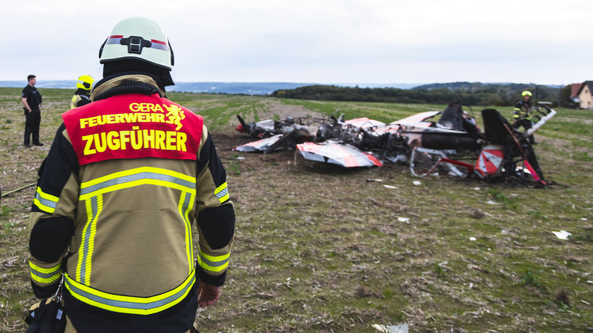 Feuerwehrleute stehen neben dem Wrack eines abgestürzten Flugzeugs nahe Gera | dpa