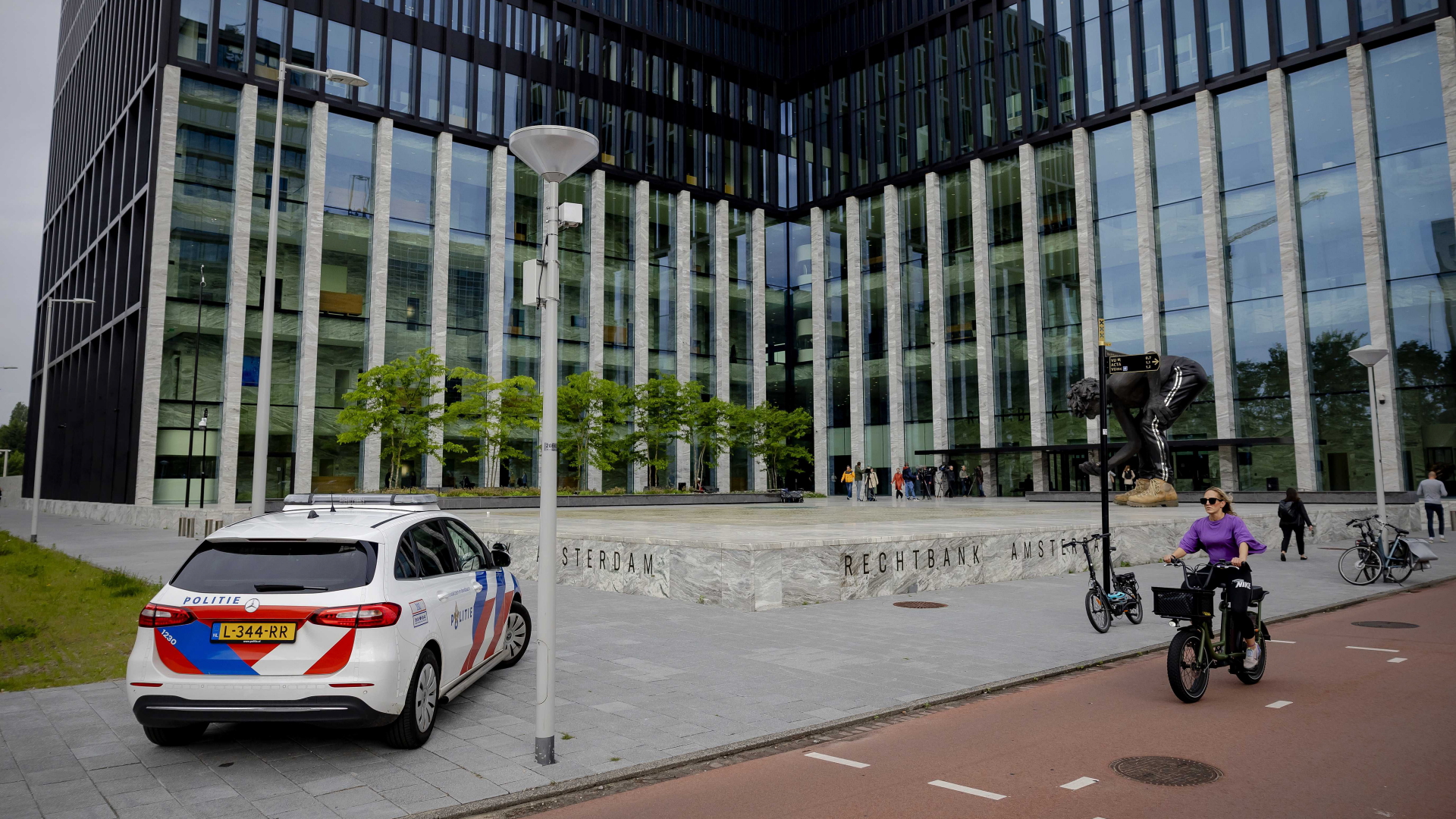 Radfahrer und ein Polizeiwagen vor dem Gerichtsgebäude in Amsterdam. | EPA