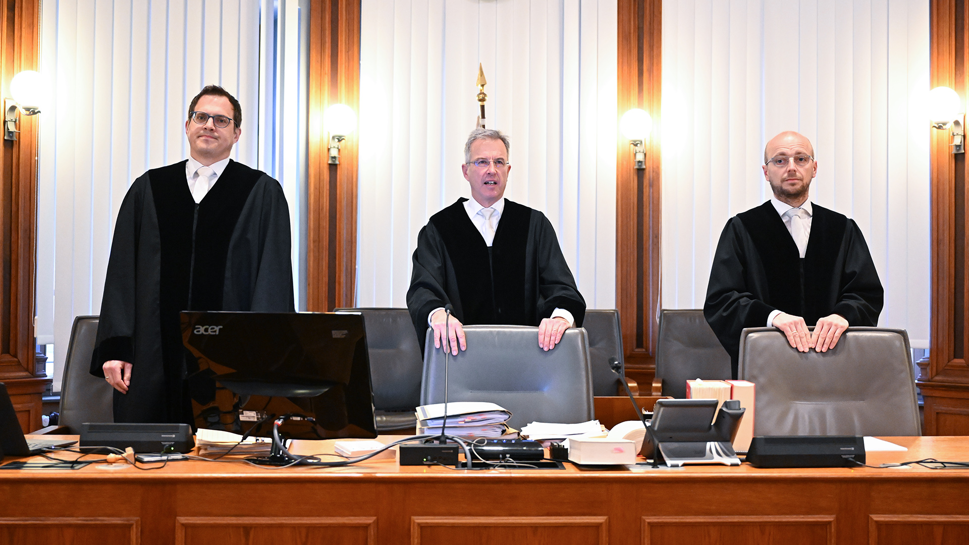 Das Leipziger Dienstgericht für Richter, unter Vorsitz von Hanns-Christian John (Mitte), steht vor Prozessbeginn im Verhandlungssaal des Landgerichts Leipzig. | dpa