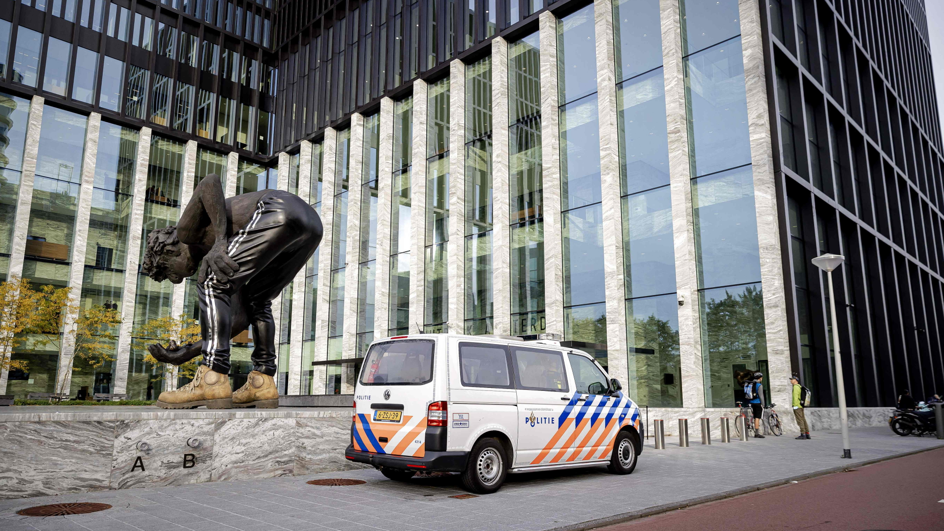 Ein Polizeiauto vor dem Gerichtsgebäude in Amsterdam, in dem der Prozess um den Mord am Journalisten de Vries stattfindet. | AFP