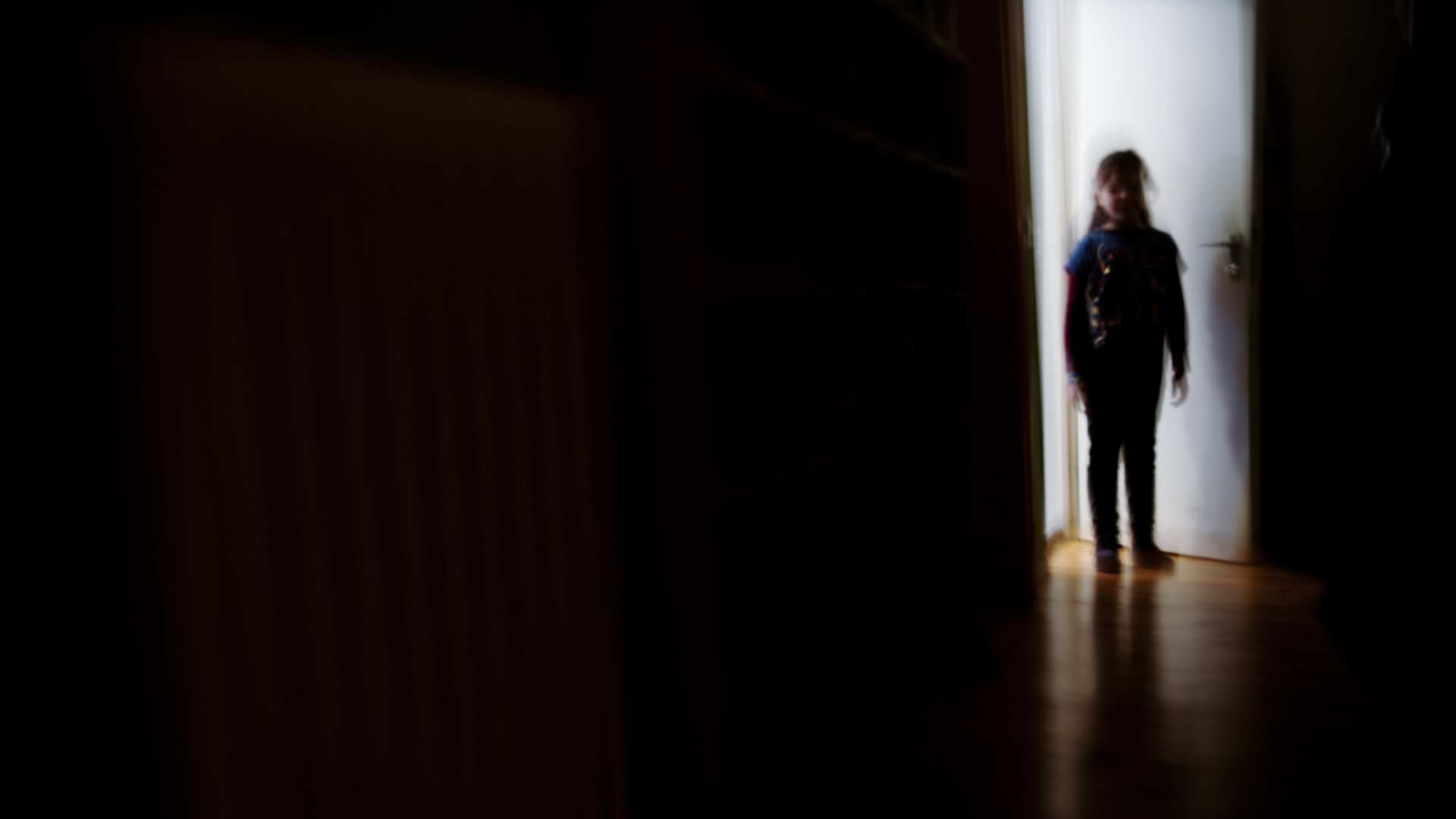 Ein Kind steht in einer Zimmertür
