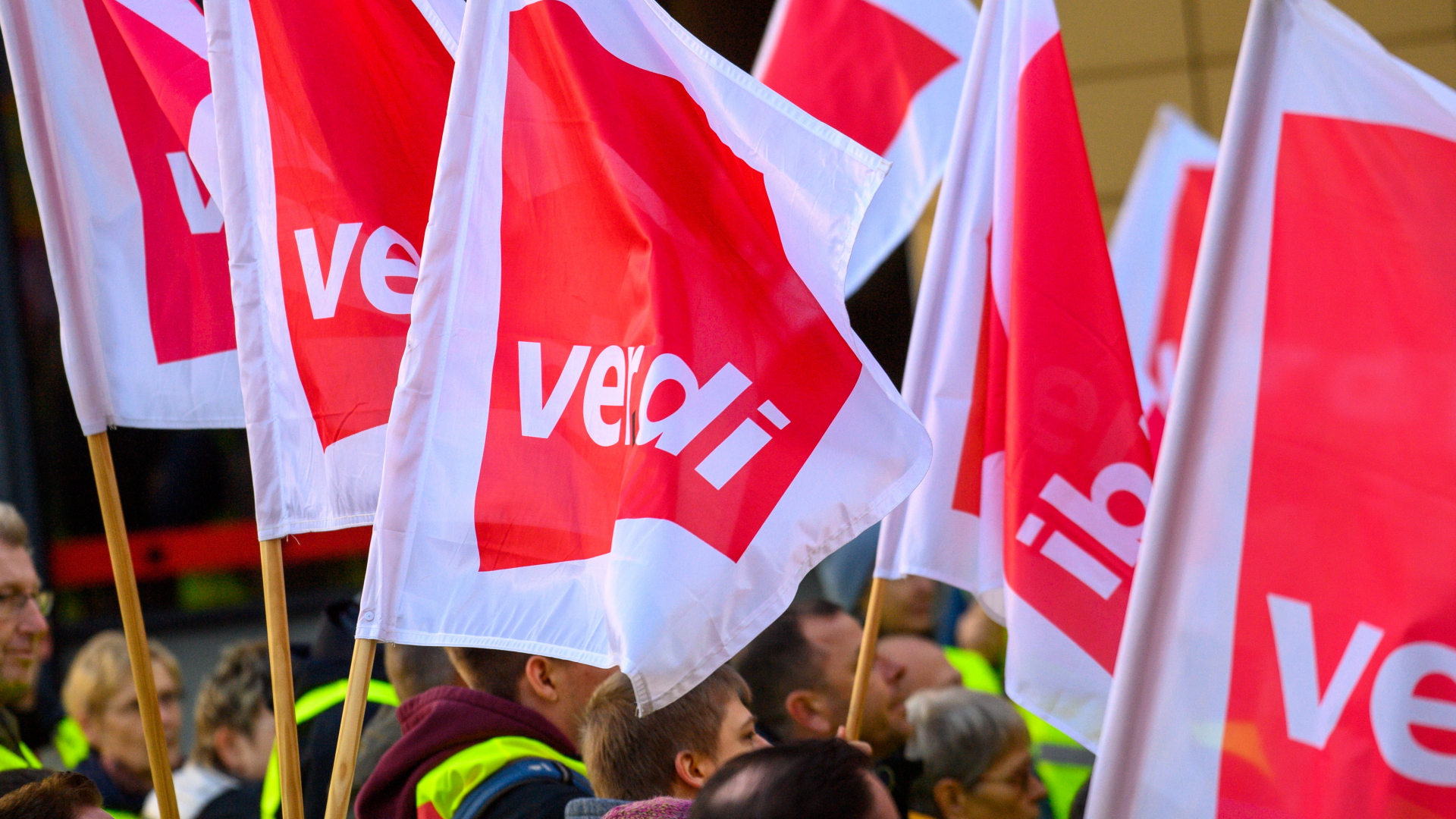 Streikende stehen mit Ver.di-Fahnen vor der Gewerkschaftszentrale in Magdeburg