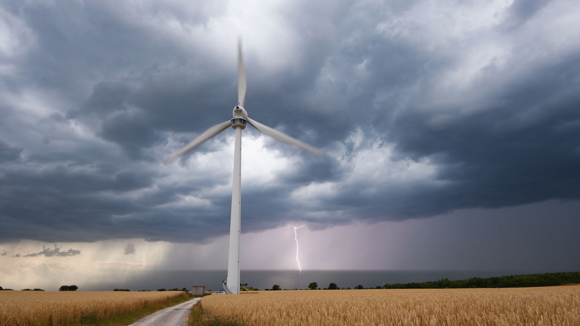 Eine Unwetterfront zieht über ein Feld mit einem Windrad in der Region Hannover.  | dpa