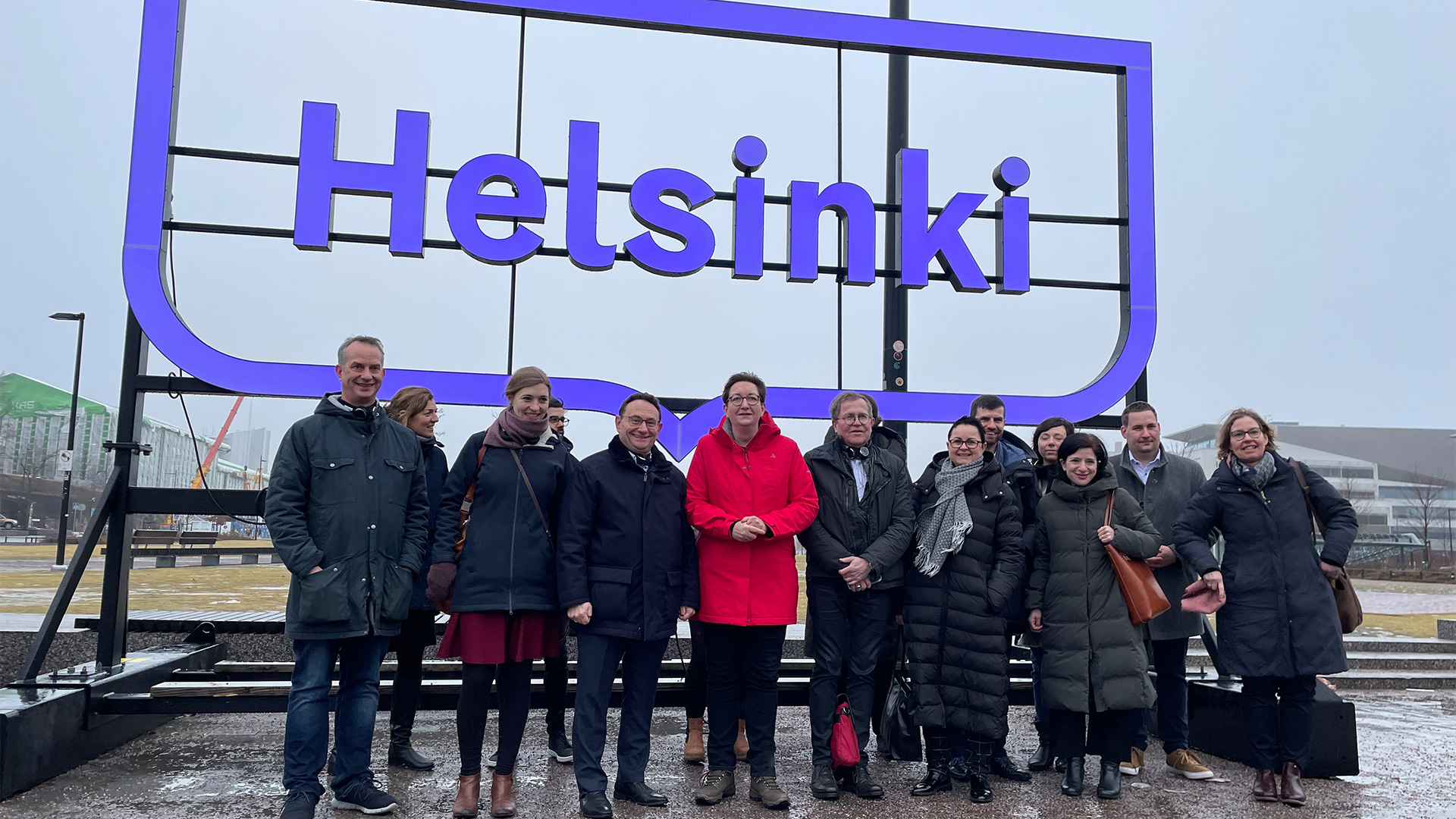 Gruppenbild mit Klara Geywitz (MItte) vor einem Schild mit der Aufschrift "Helsinki". | Justus Kliss