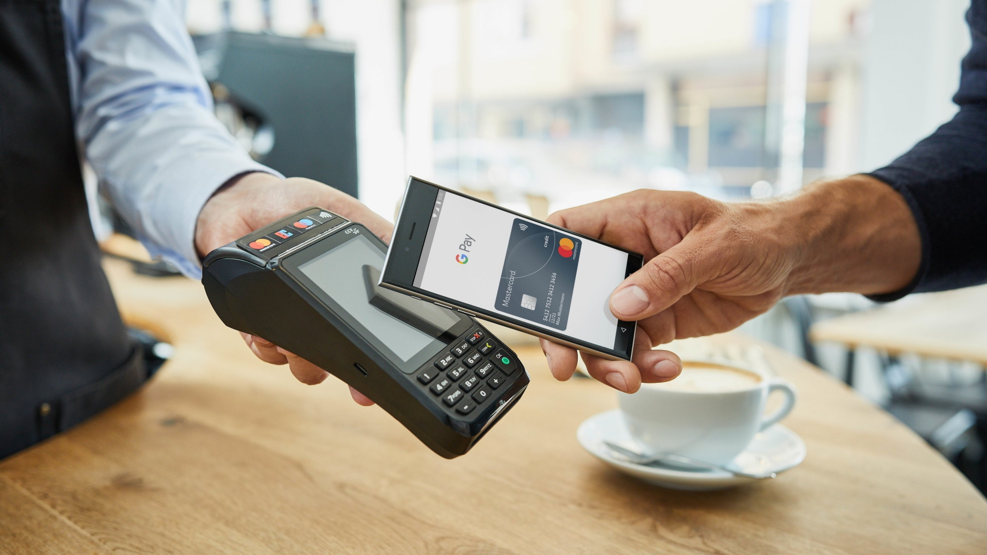 Ein Android-Handy wird an ein Lesegerät gehalten, um mit Google Pay zu bezahlen. | obs