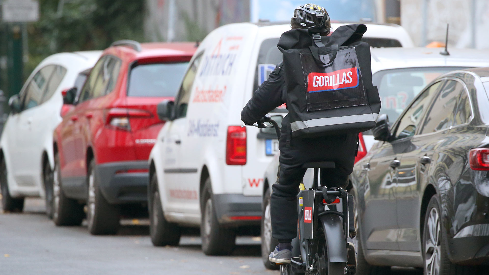 Fahrer des Lebensmittel-Lieferdienstes Gorillas mit einer Transporttasche des Unternehmens