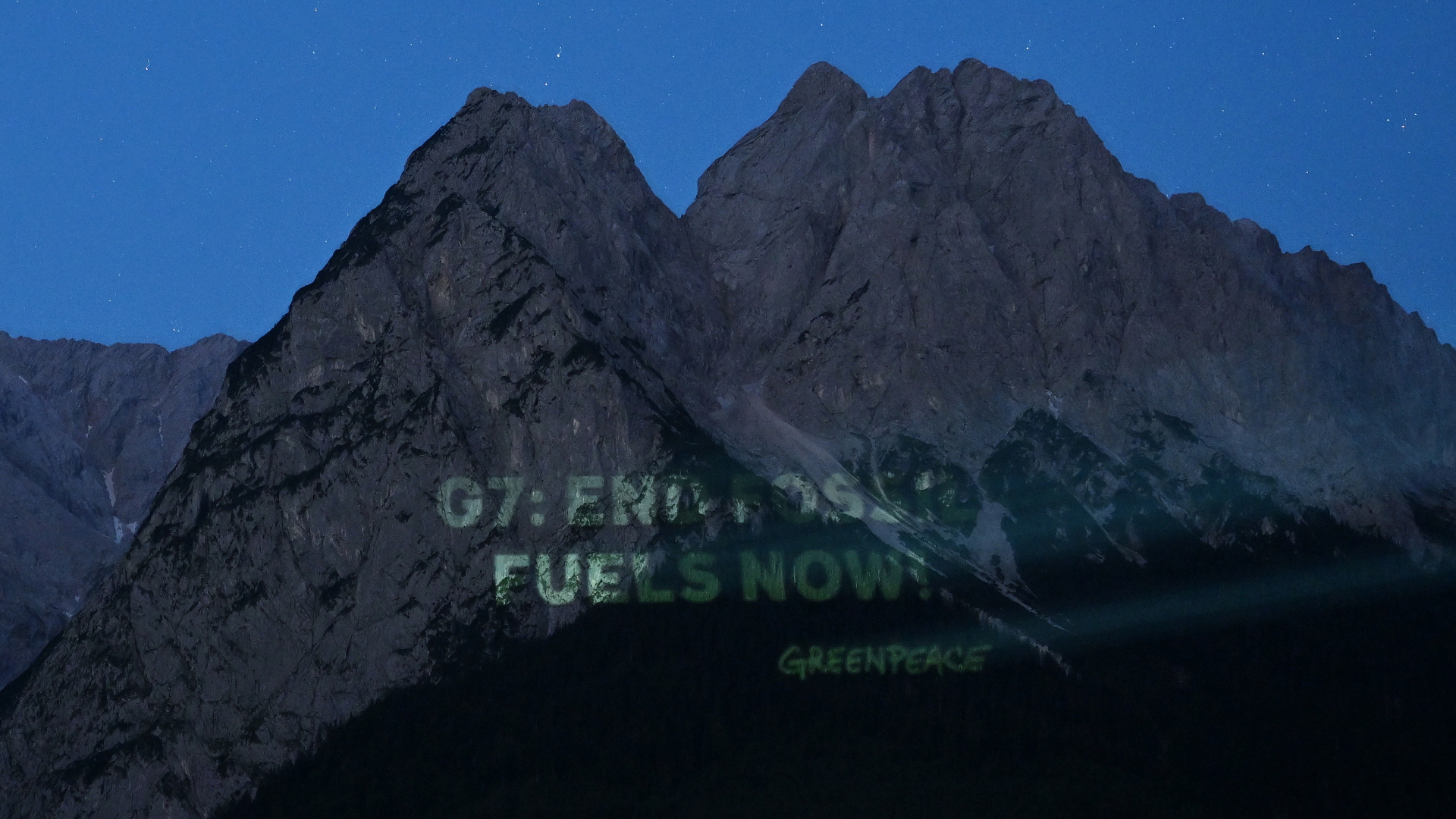 Schriftzug "G7: End Fossil Fuels now! Greenpeace" an einer Felswand | dpa