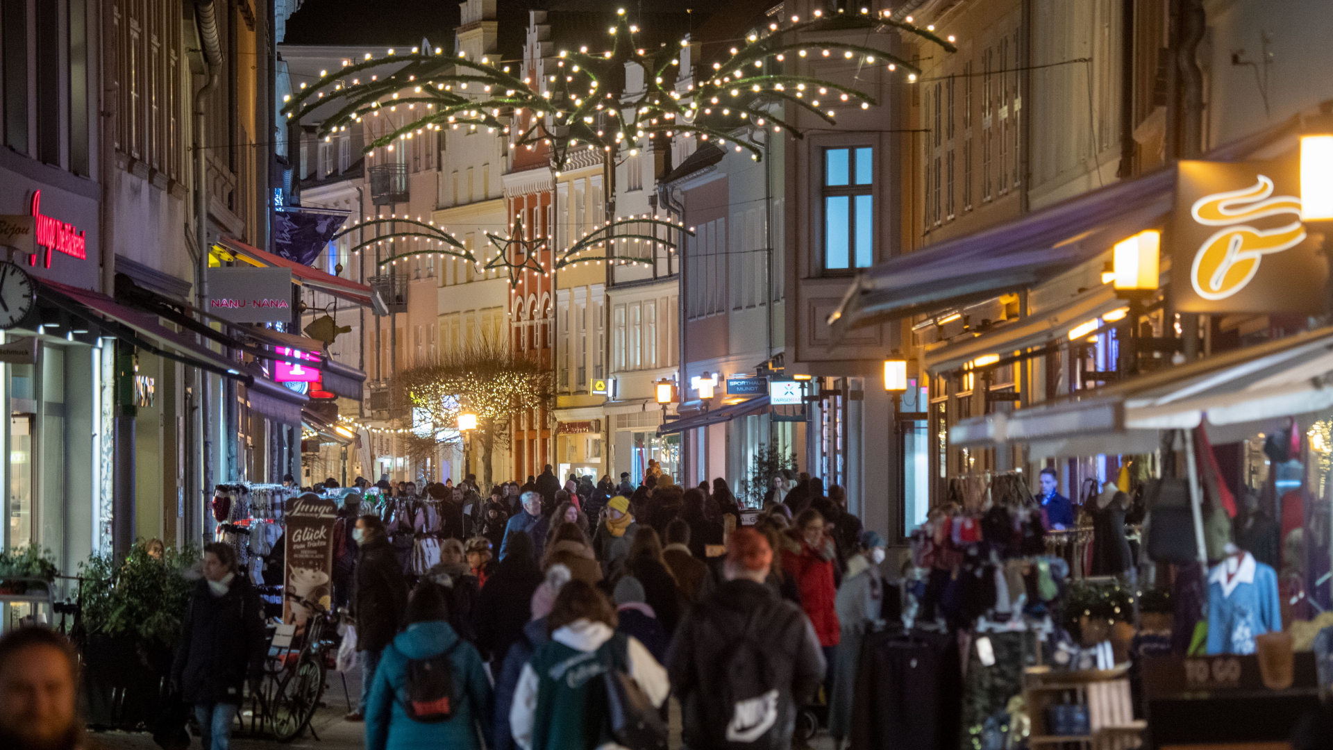 Menschen in der weihnachtlich geschmückten Altstadt von Greifswald. | dpa