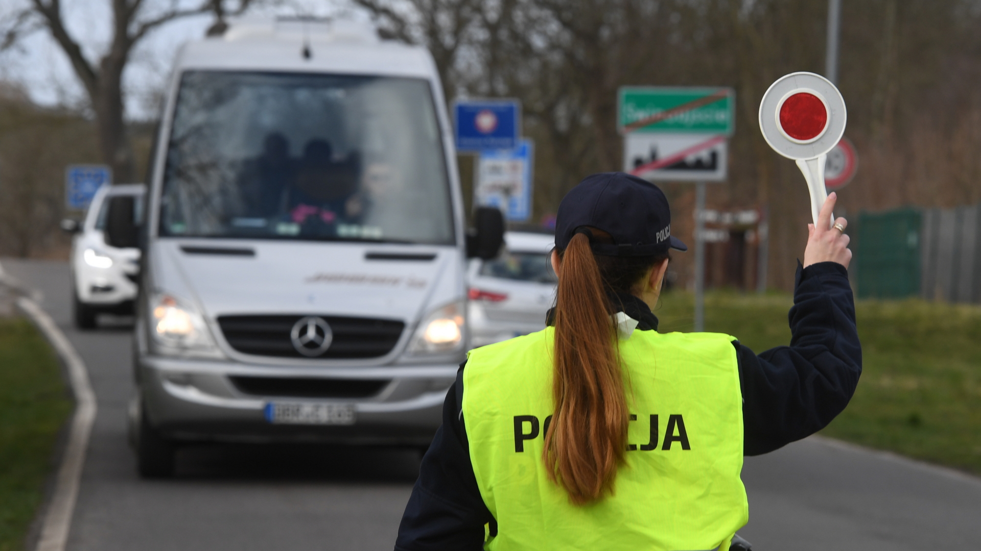 Eine polnische Polizistin winkt vor dem Grenzübergang Garz in Swinoujscie (Swinemünde) in Polen auf der Insel Usedom an der polnisch-deutschen Grenze einen Reisebus zur Kontrolle raus. | dpa